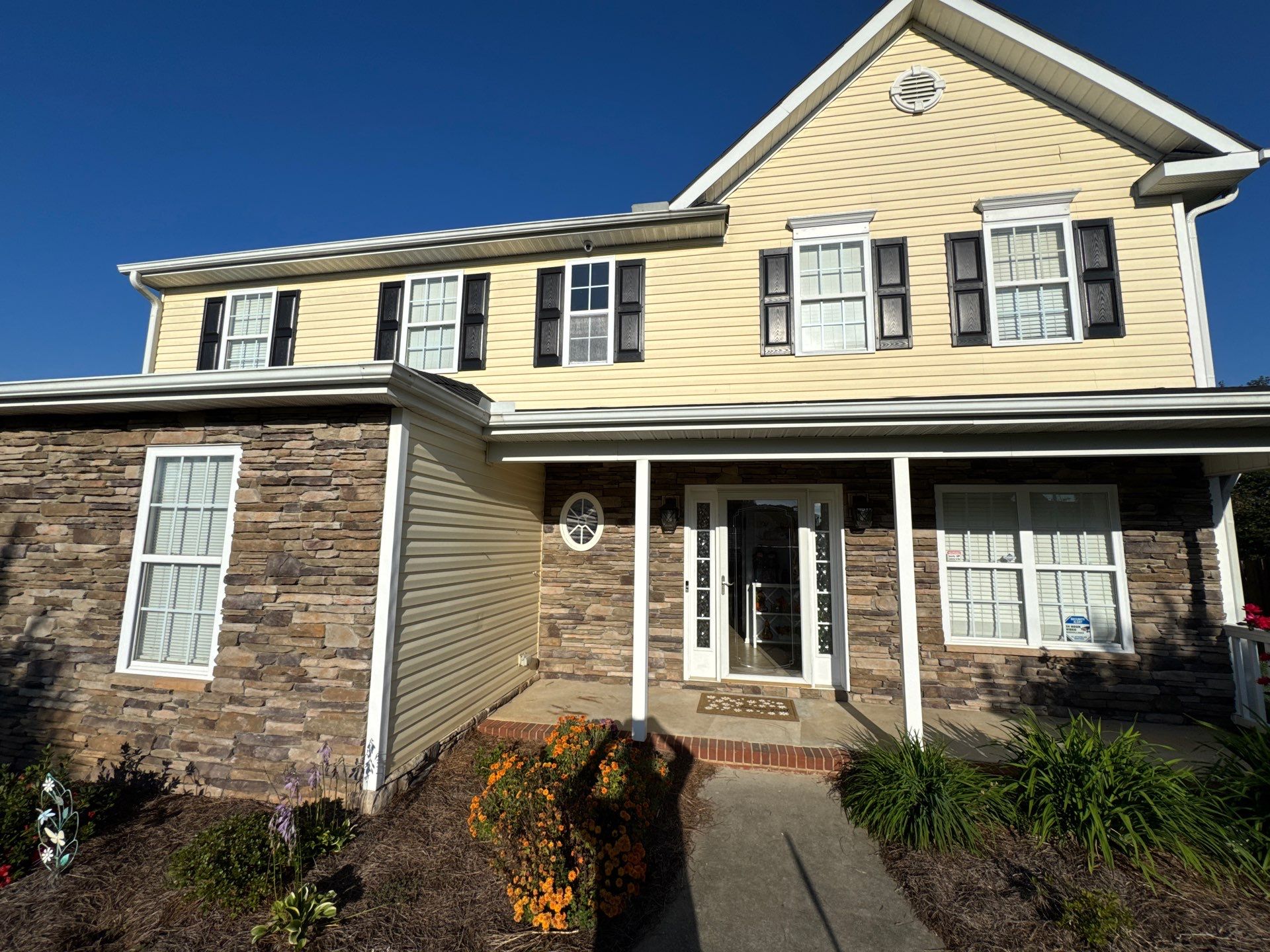 the service shown is cleaning of siding and stone surfaces on a residential home