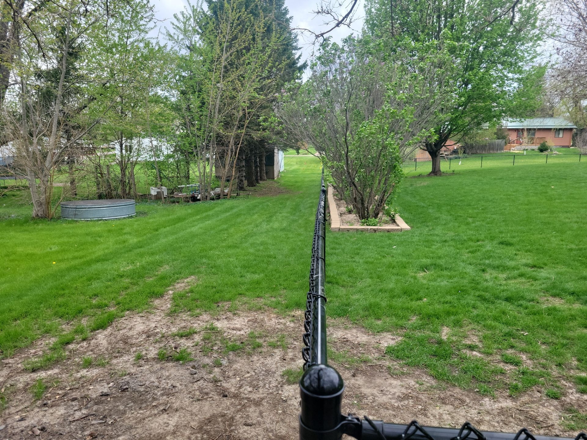 Residential Black Vinyl-Coated Chain Link Perimeter Fence in Garwin by Perfect Picket Fence and Stain