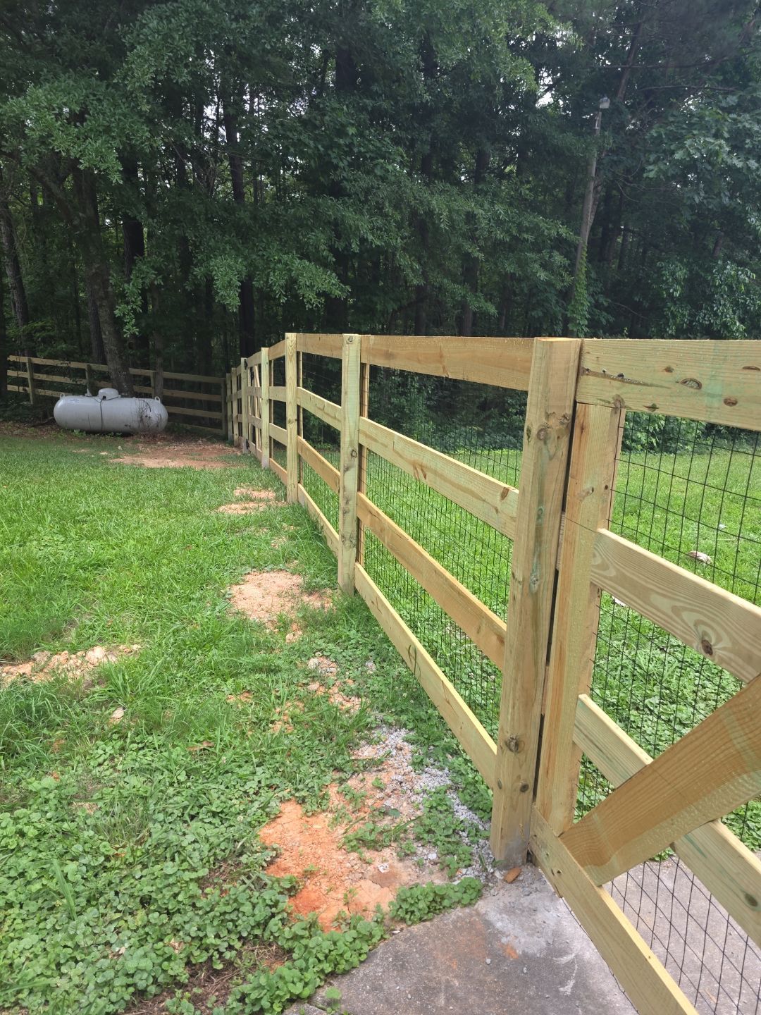 Fence Installation of a 4 Rail Ranch Style Fence with Welded Wire by Titans of Timber Fence & Stain