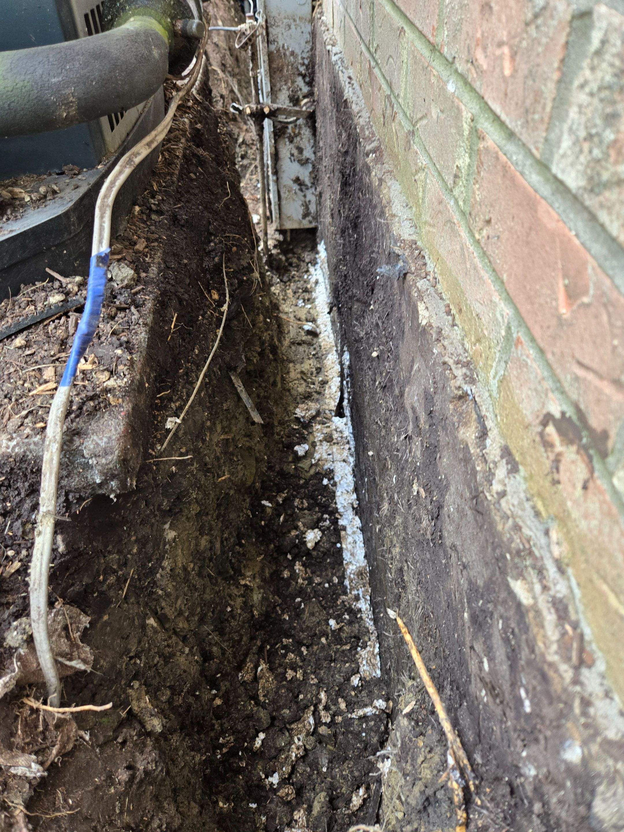 Burial of Sump Pump and Down Spout Discharges and Partial Waterproofing of Wall by Allied Water Services