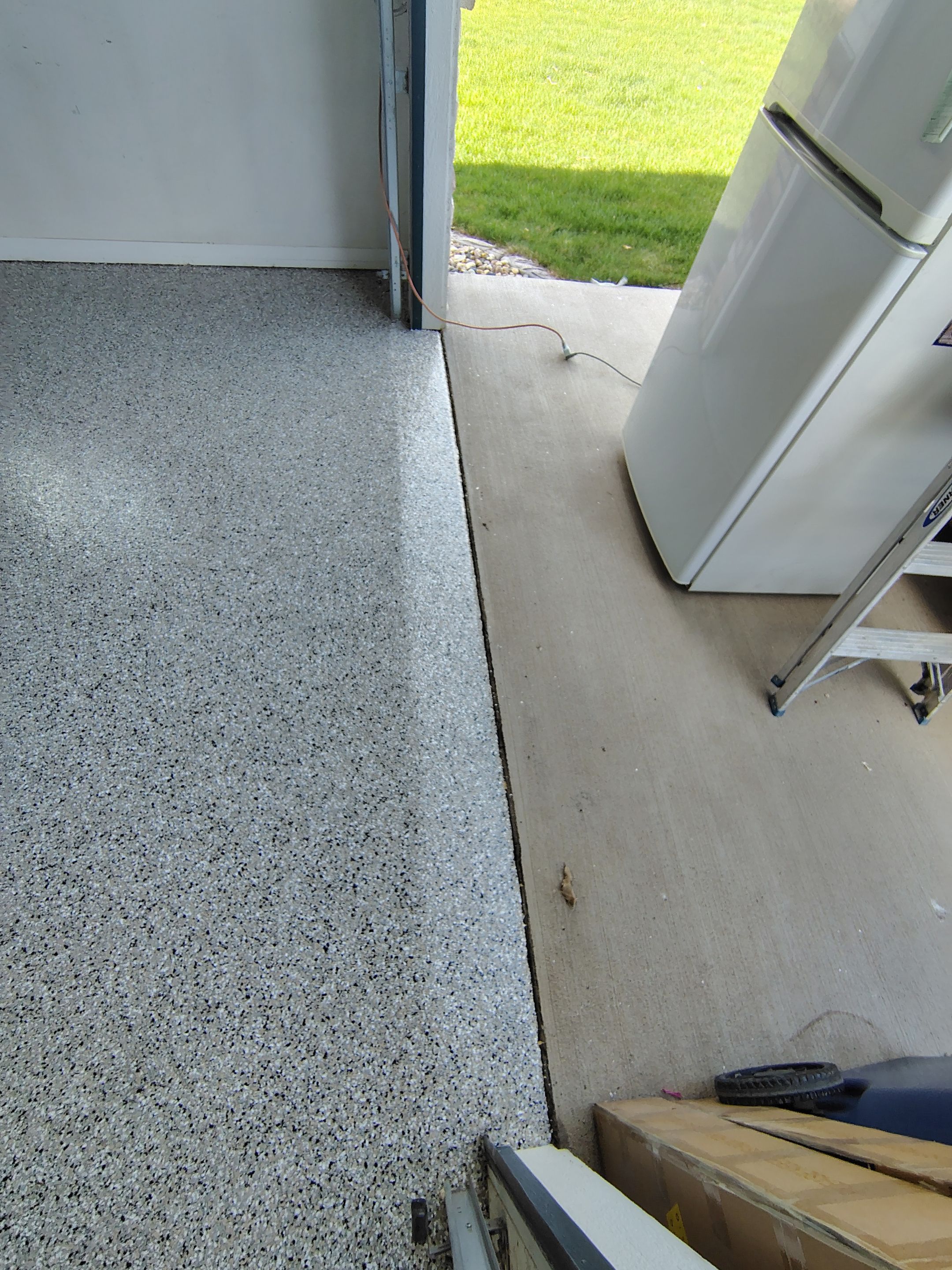 Speckled Polyaspartic Garage Floor Coating Installation in Dell Rapids by Select Painting, Coatings & Garage Cabinets