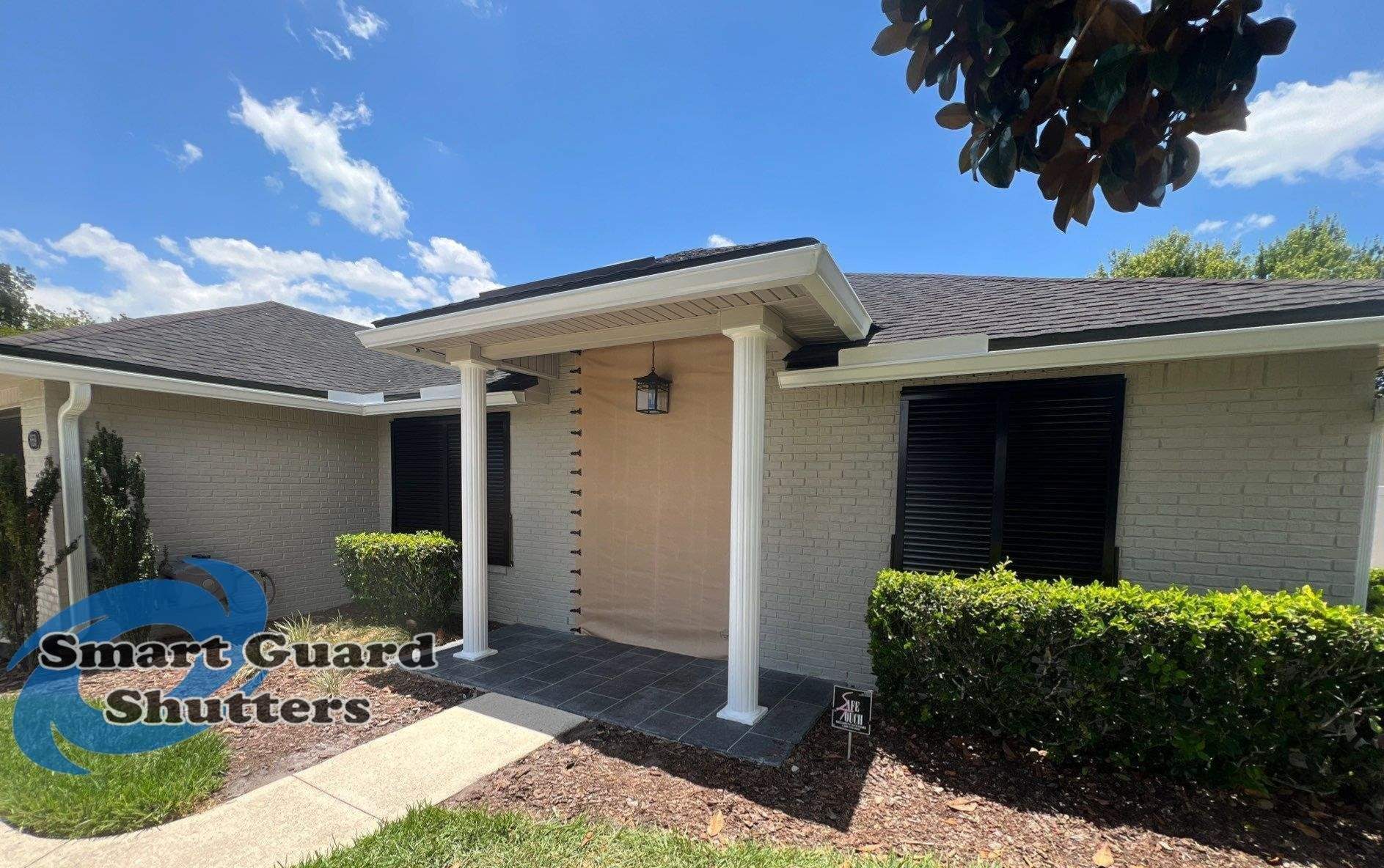 Hurricane Protection using Bahamas in Traffic Black and Fabric in Tan by Smart Guard Shutters