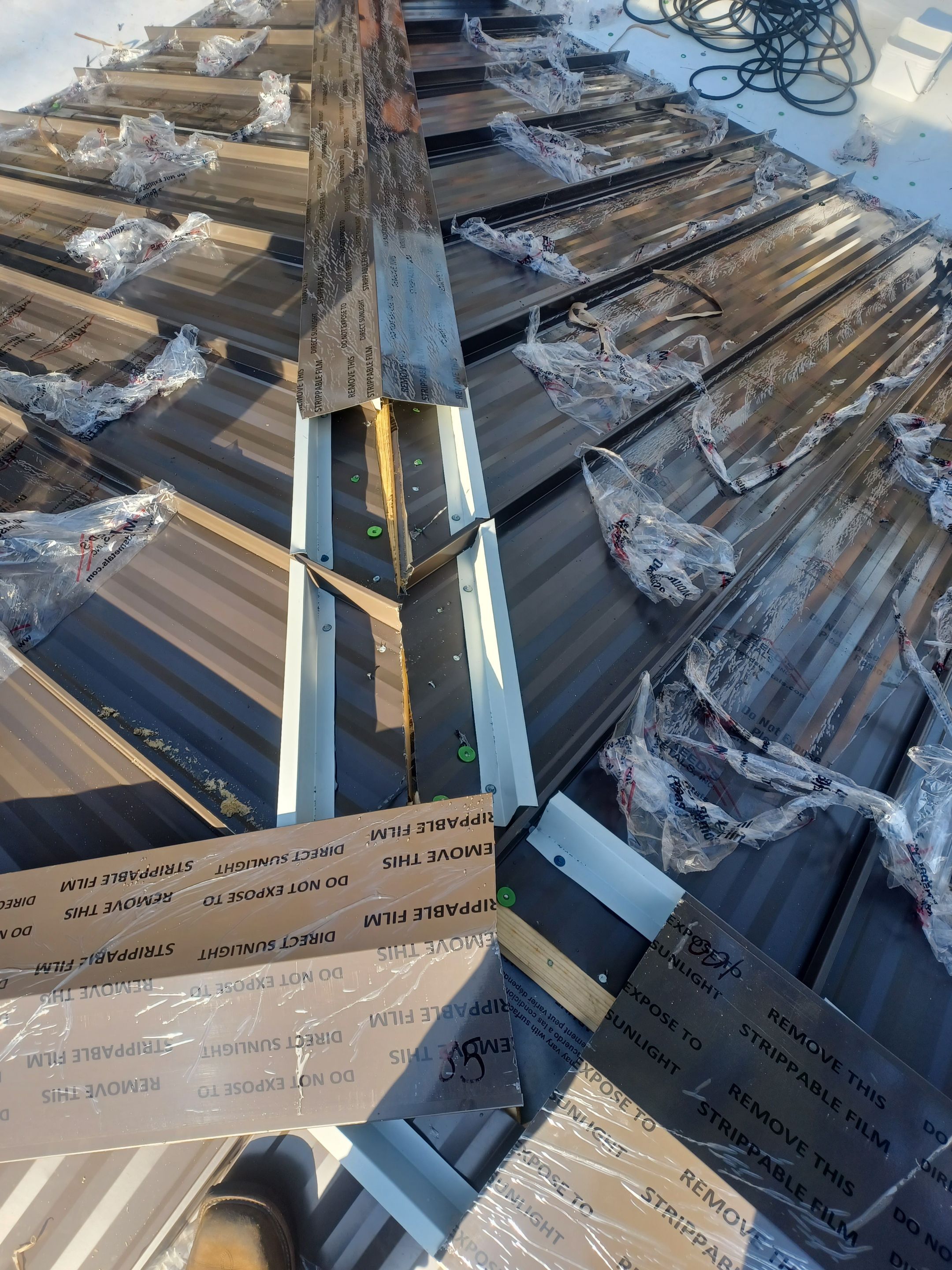 Residential Roofing Installation using PVC membrane and 24 gauge Standing Seam Metal by Hostetler Roofing