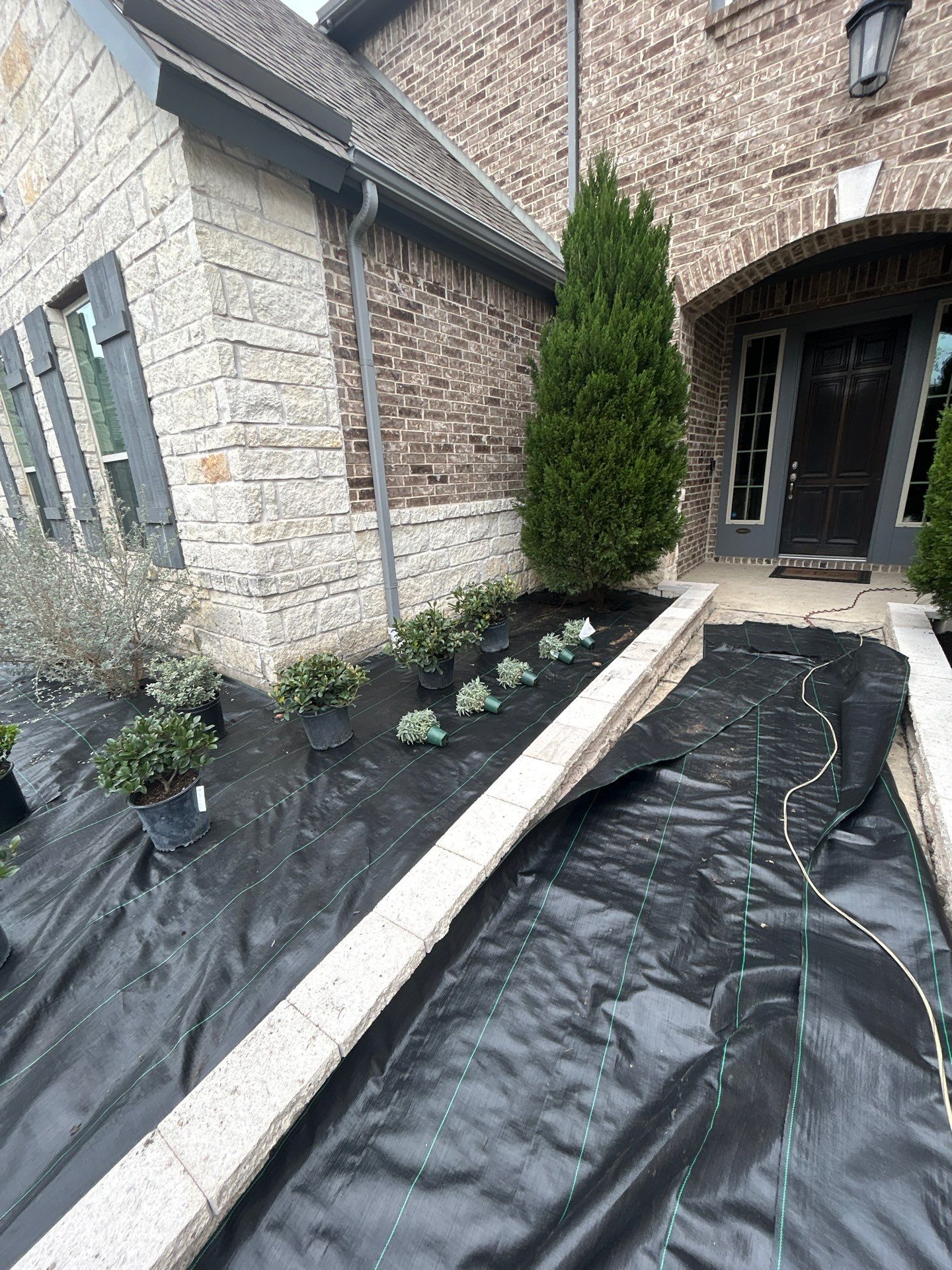 🌿✨ Darlene & Andrew’s Amazing Curb Appeal Transformation  Some projects are more than just landscaping—they’re a conversion of curb appeal from the ground up. For Darlene & Andrew, Alejandro and the Texas Urban Team designed and delivered a complete solution that reshaped their flower beds, solved drainage challenges, and gave new life to the sideyard.  💡 From planning to execution, every step was tailored to build both beauty and functionality:  🌸 Flower Beds, Reinvented  Demolition of old beds, plants, and mulch.  Fresh soil preparation, weed protection, and a brand-new retainer wall built with hand-cut stone and decorative caps.  Carefully selected plants and garden mix to ensure health and visual harmony.  💧 Drainage & Irrigation Upgrades  Outdated corrugated pipes replaced with PVC drainage lines to carry water safely away from the foundation.  New irrigation system combining drip lines and sprinklers—watering plants while keeping the house walls protected.  Sideyard drainage extended with catch basins and PVC piping to prevent water pooling and foundation stress.  🚶 Functional Sideyard with Walkway & Trash Area  Graded and leveled sideyard to manage runoff.  Installed a modern gravel and paver walkway for easy access.  Built a firm and tidy concrete-paver pad for trash containers—making the space both practical and polished.  🛠️ Stonework & Craftsmanship  Every stone in the retainer wall was cut, set, and secured by the team of handcrafters, ensuring a durable build that doubles as a design statement.  ✅ Outcome: Darlene & Andrew’s property now has better drainage, a clean and organized sideyard, and elegant new flower beds—all designed for long-term durability and lasting beauty.  📢 Before hiring anyone, review our portfolio. Our work speaks louder than words—each project is a blend of function, protection, and design crafted to last. by Texas Urban Elements