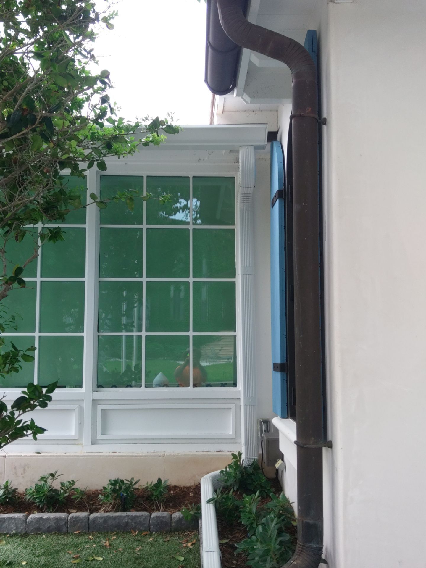 Seamless aluminum gutter installation in Sarasota, FL using 3x4 elbow downspouts combined with round downspouts by Gutter Professors