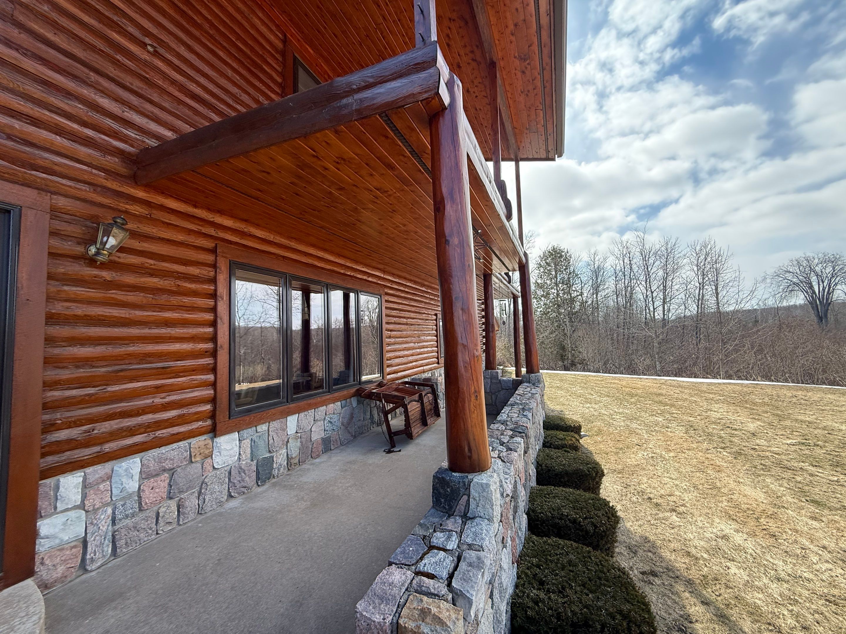 Sunesta Retractable Screen Installation on a Petoskey Log Home Porch by Rainbow Seamless Systems