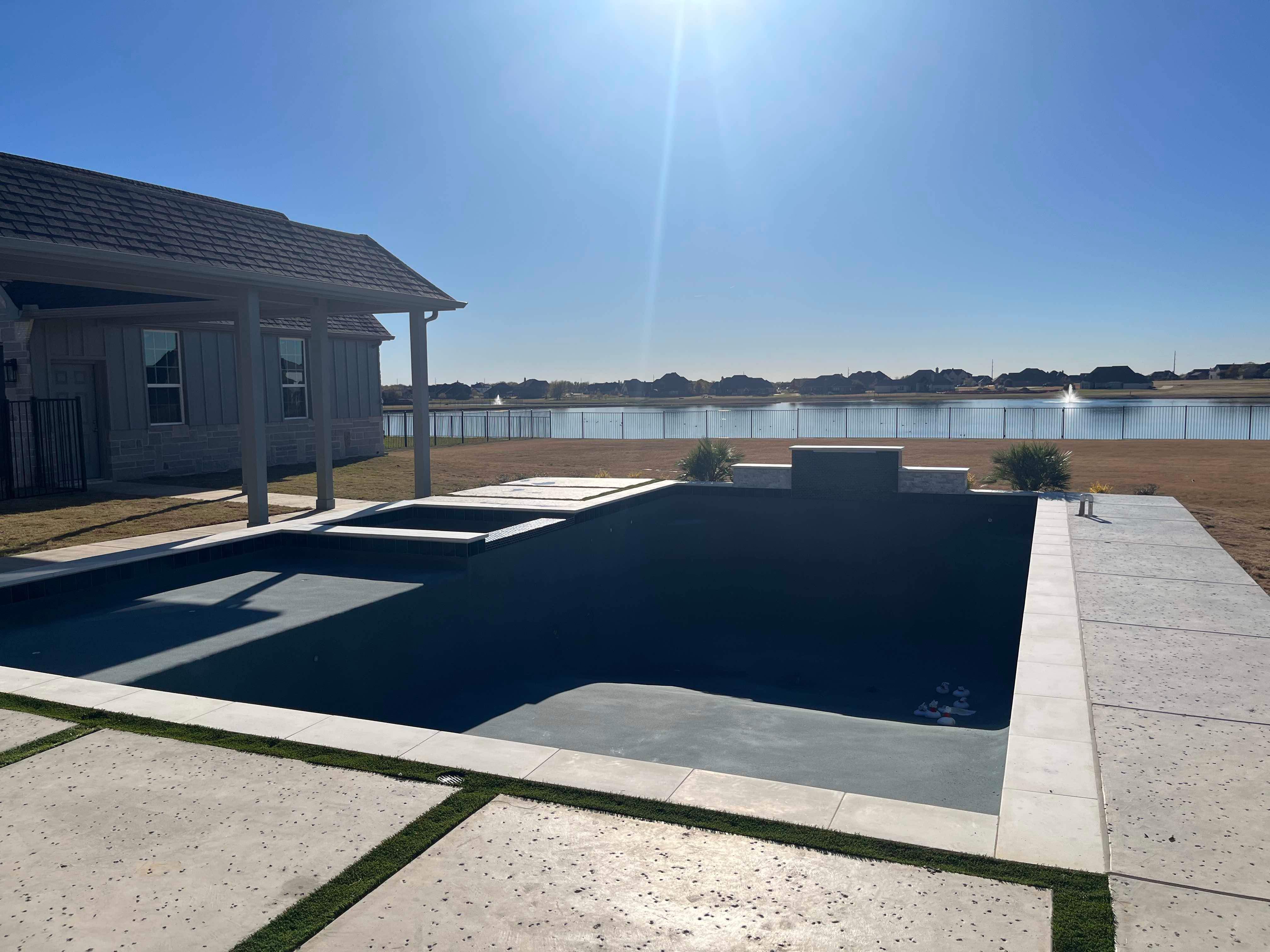 Modern Lakefront Pool with Raised Spa and Dark Interior by Pinnacle Pools and Spas - DFW