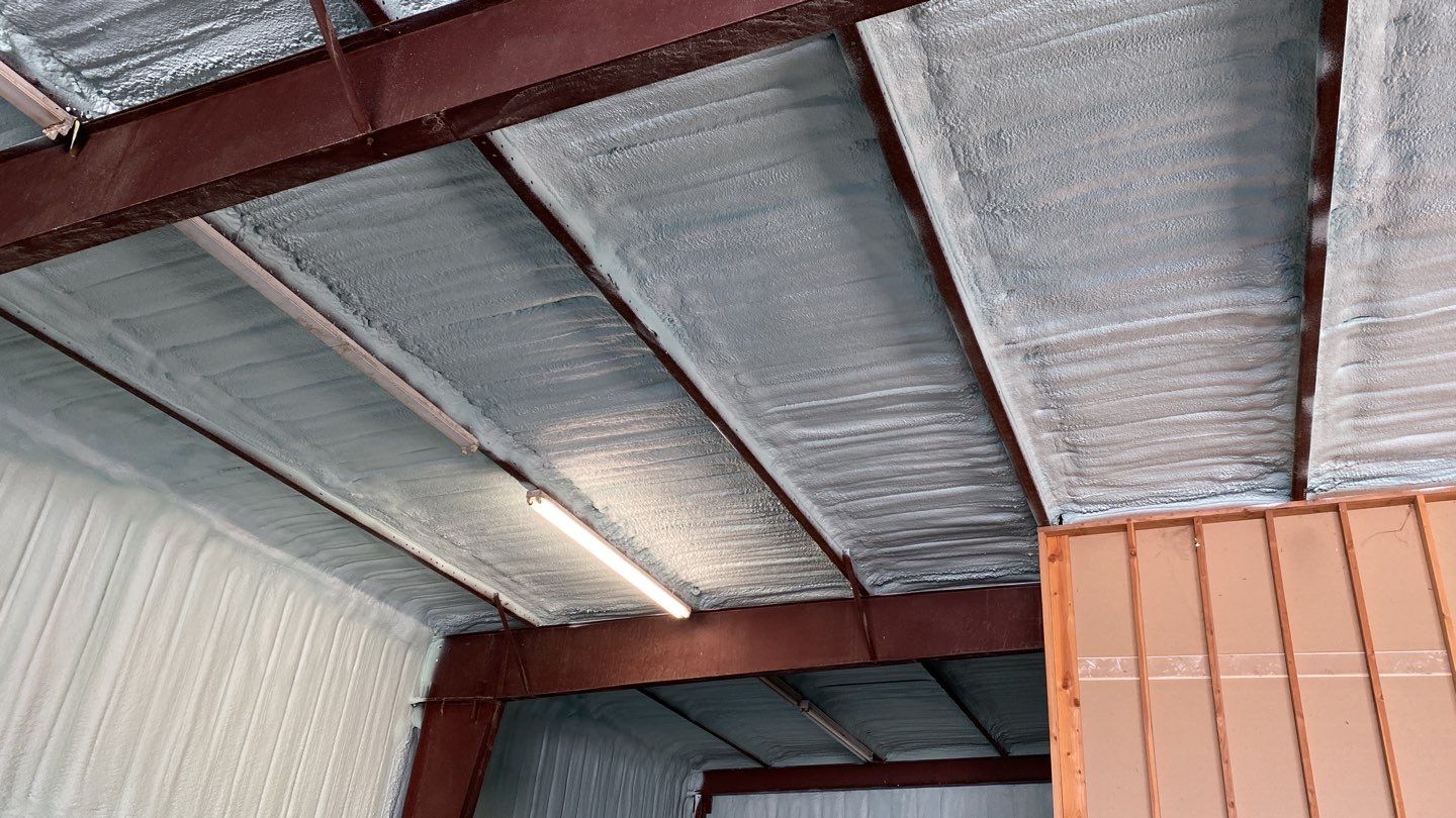 Spray foam insulation on inside of metal industrial building by Straight Edge Roofing Inc