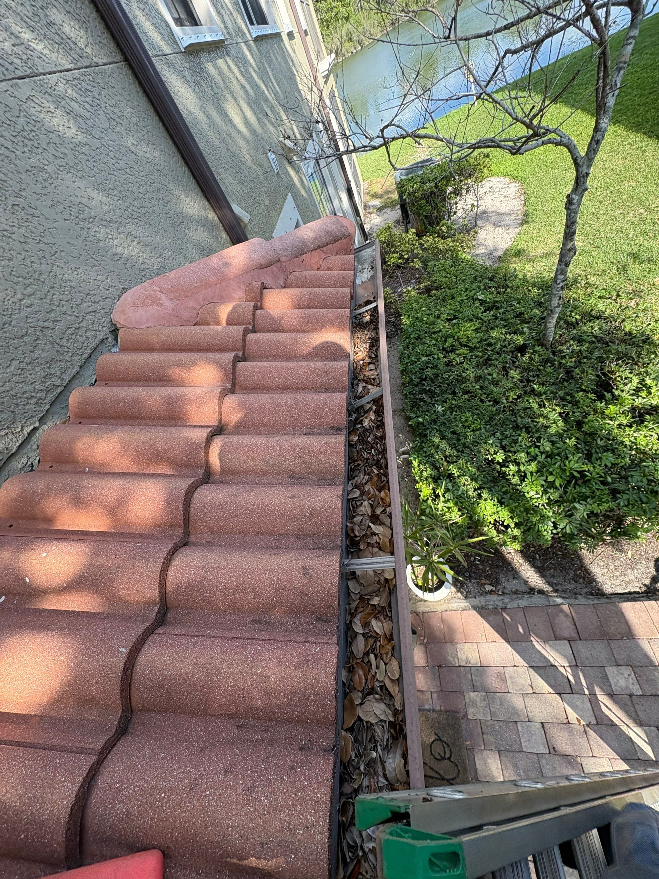 Commercial gutter cleaning Lehigh Acres & Bonita Springs, FL before photo with filled gutters