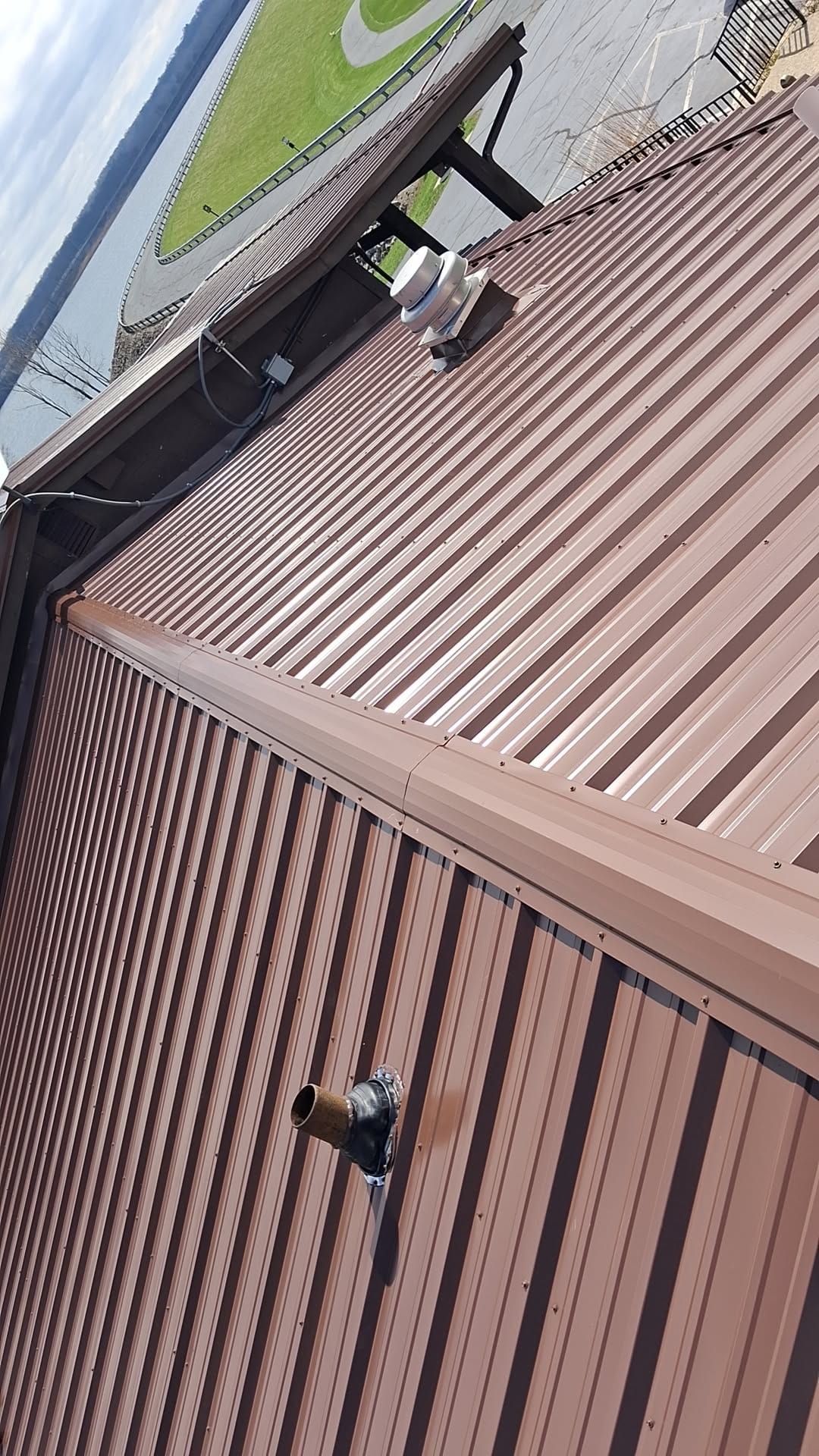 Brown R-Panel metal roof with solar by Atlas Roofing & Restoration