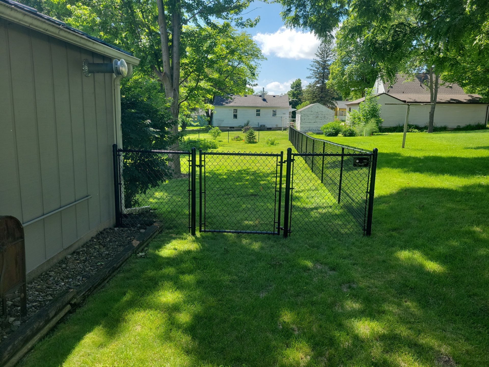 Black Chain Link Perimeter Fence and Driveway Gate in Waverly by Perfect Picket Fence and Stain