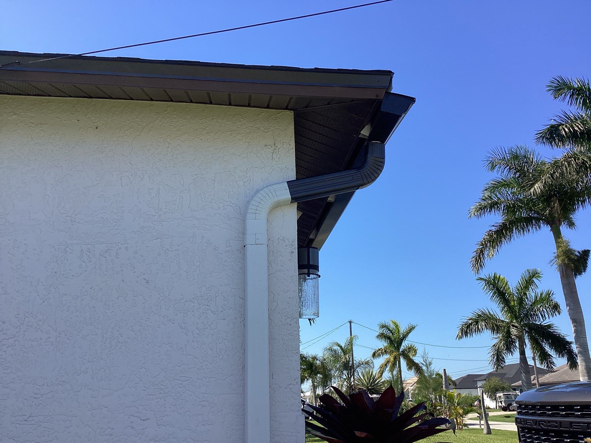 Brown Gutter + White and Brown Downspouts in Cape Coral FL by Gutter Professors
