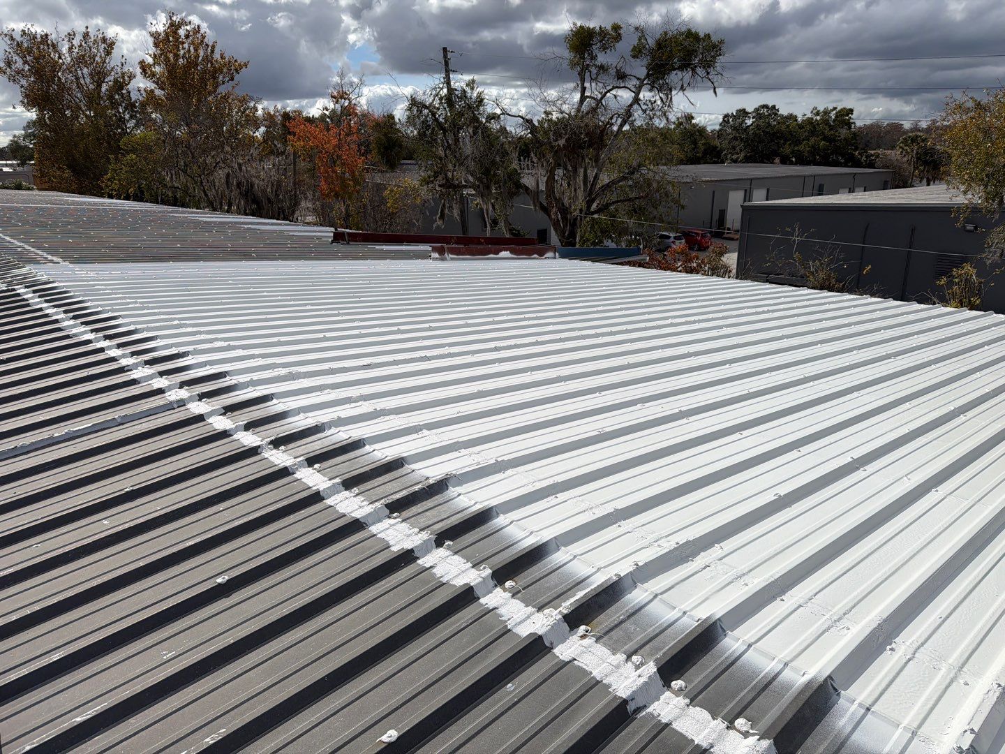 Industrial Metal Roof Restoration With Silicone Coating in Winter Park by CES Roofing