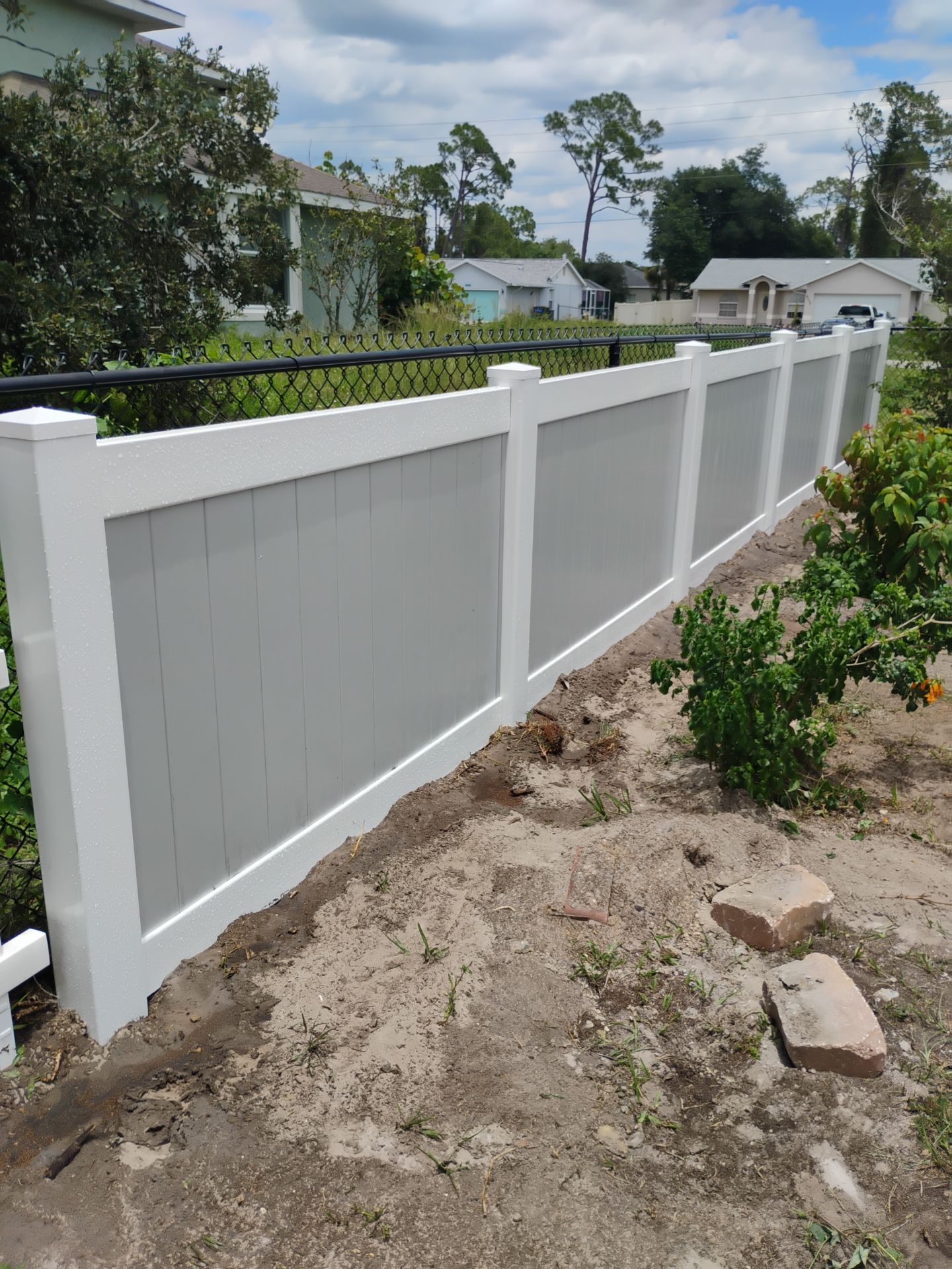 White and Gray Vinyl Privacy Fence Installation in North Port by True Fence LLC