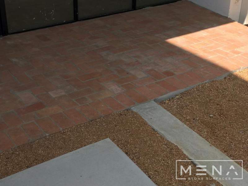 Kitchen, outdoor kitchen and pool brick floor installation by Mena stone surfaces