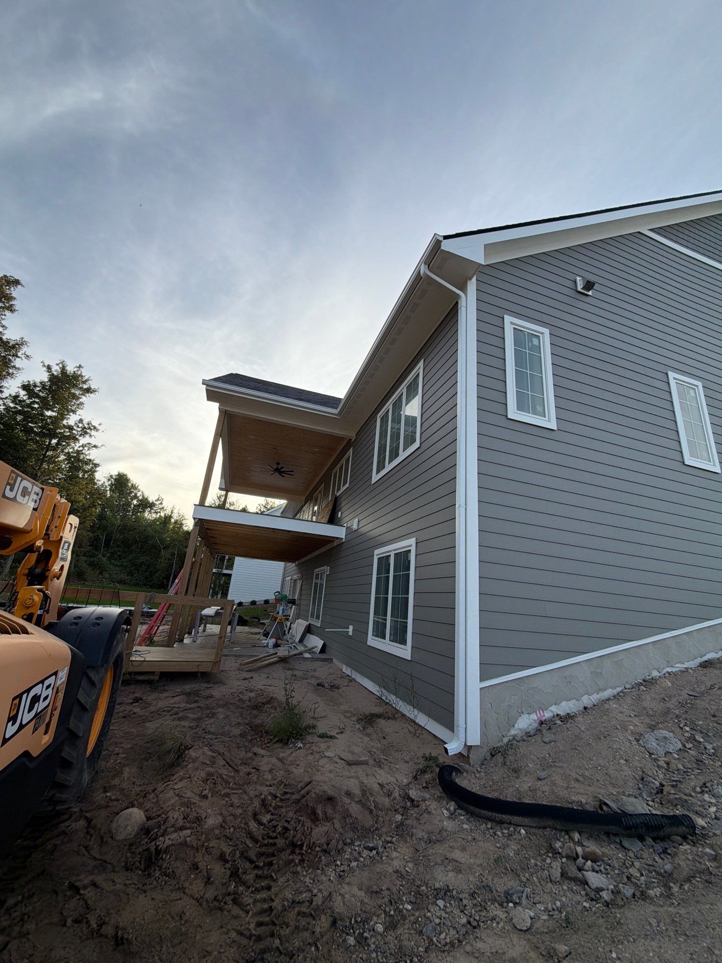 White Gutter and Downspout Installation for Petoskey New Build by Rainbow Seamless Systems