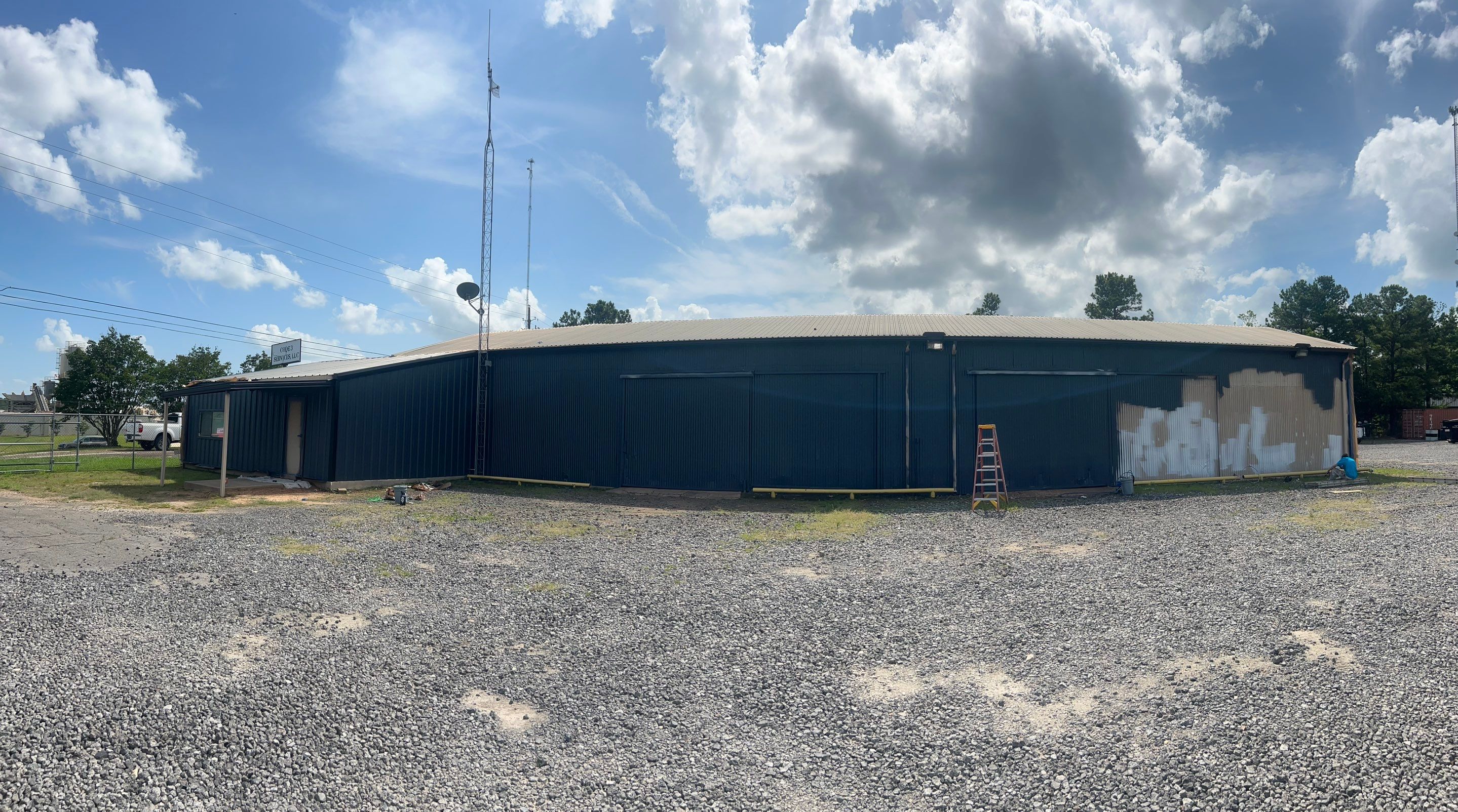 Exterior Painting in Kilgore, TX | Metal Building Transformation from White to Grey by Quality Coats Painting