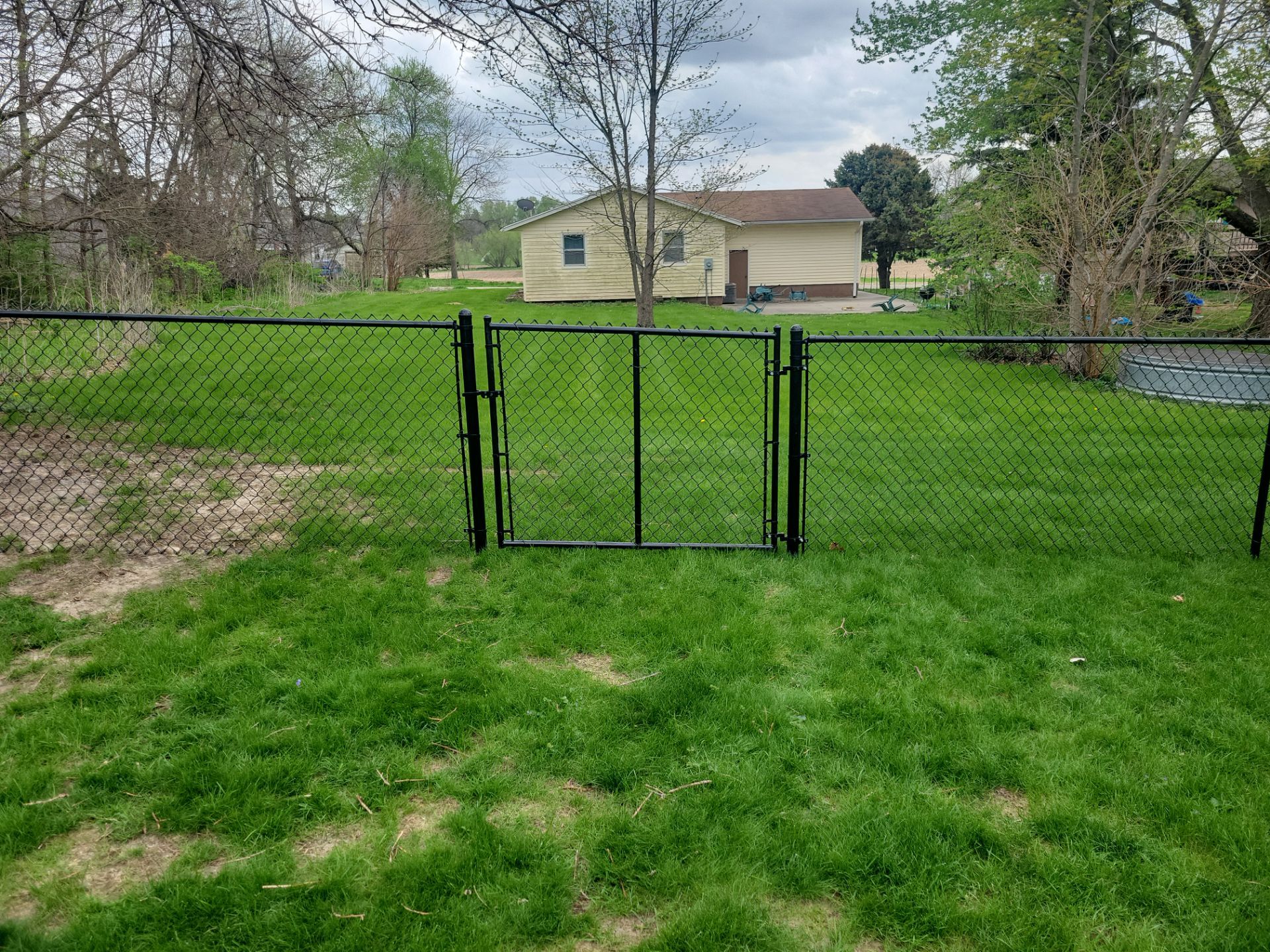 Residential Black Vinyl-Coated Chain Link Perimeter Fence in Garwin by Perfect Picket Fence and Stain