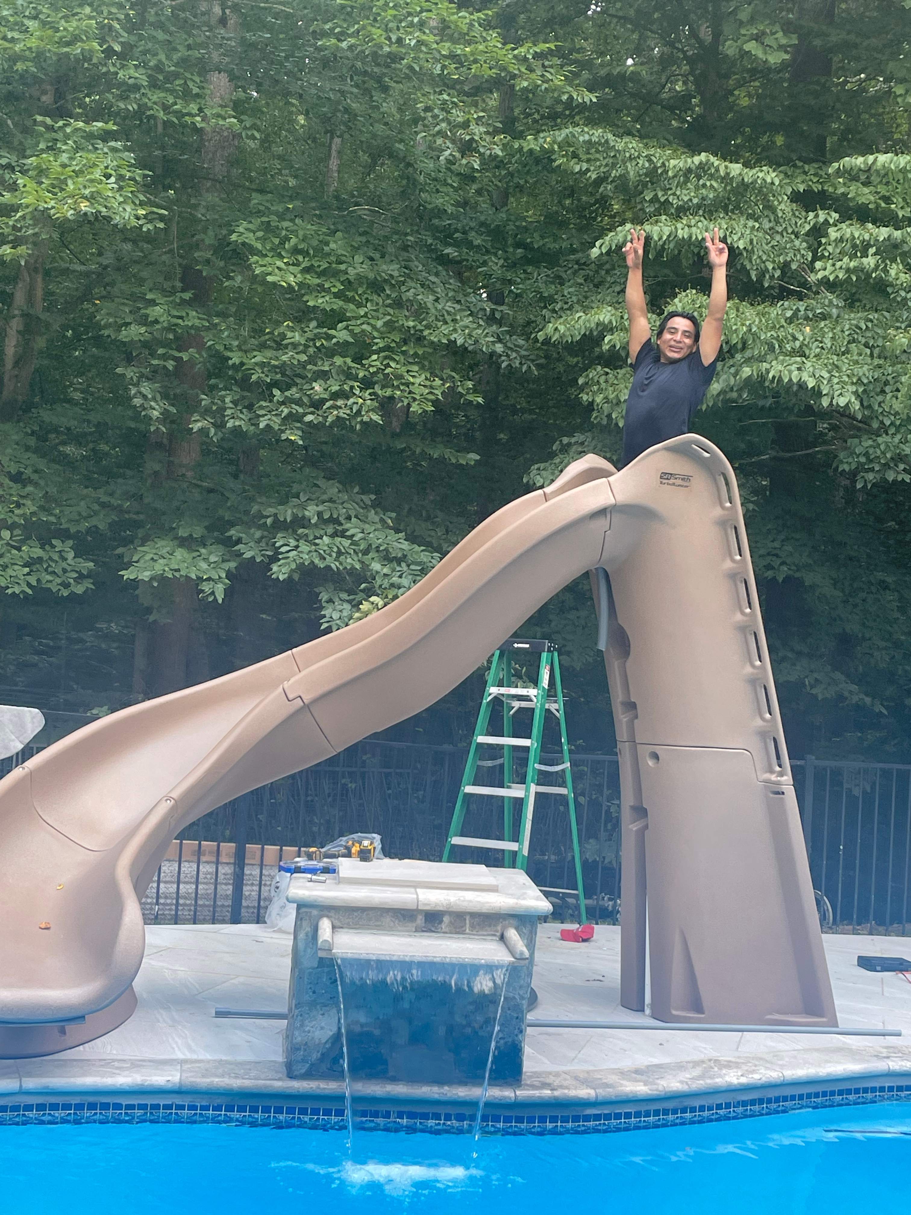 Pool Surround remodel with retaining walls, new waterfall and water slide by Fairfax Contractors, LLC