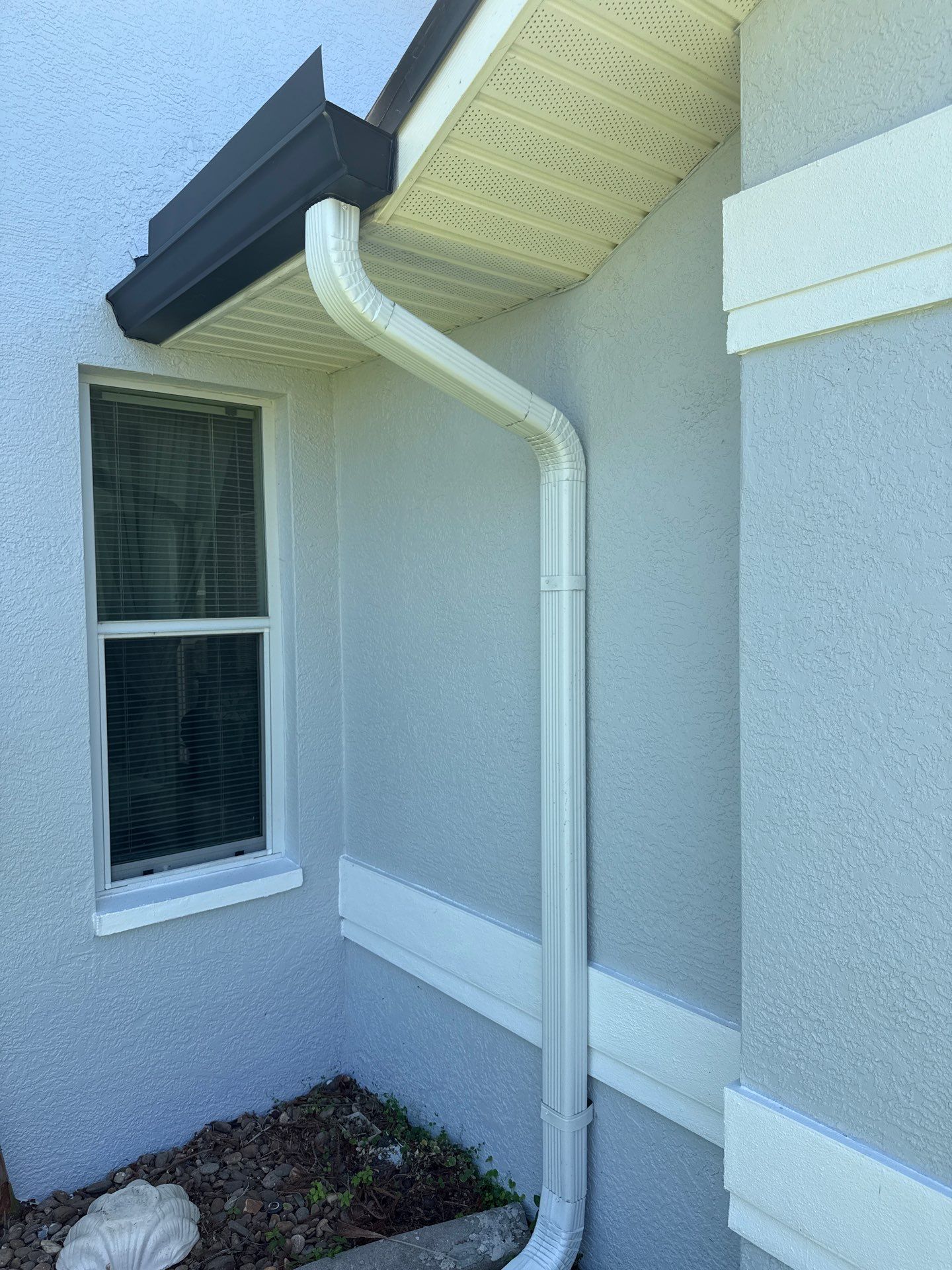 Black Seamless Gutters and White Downspouts in Cape Coral FL by Gutter Professors