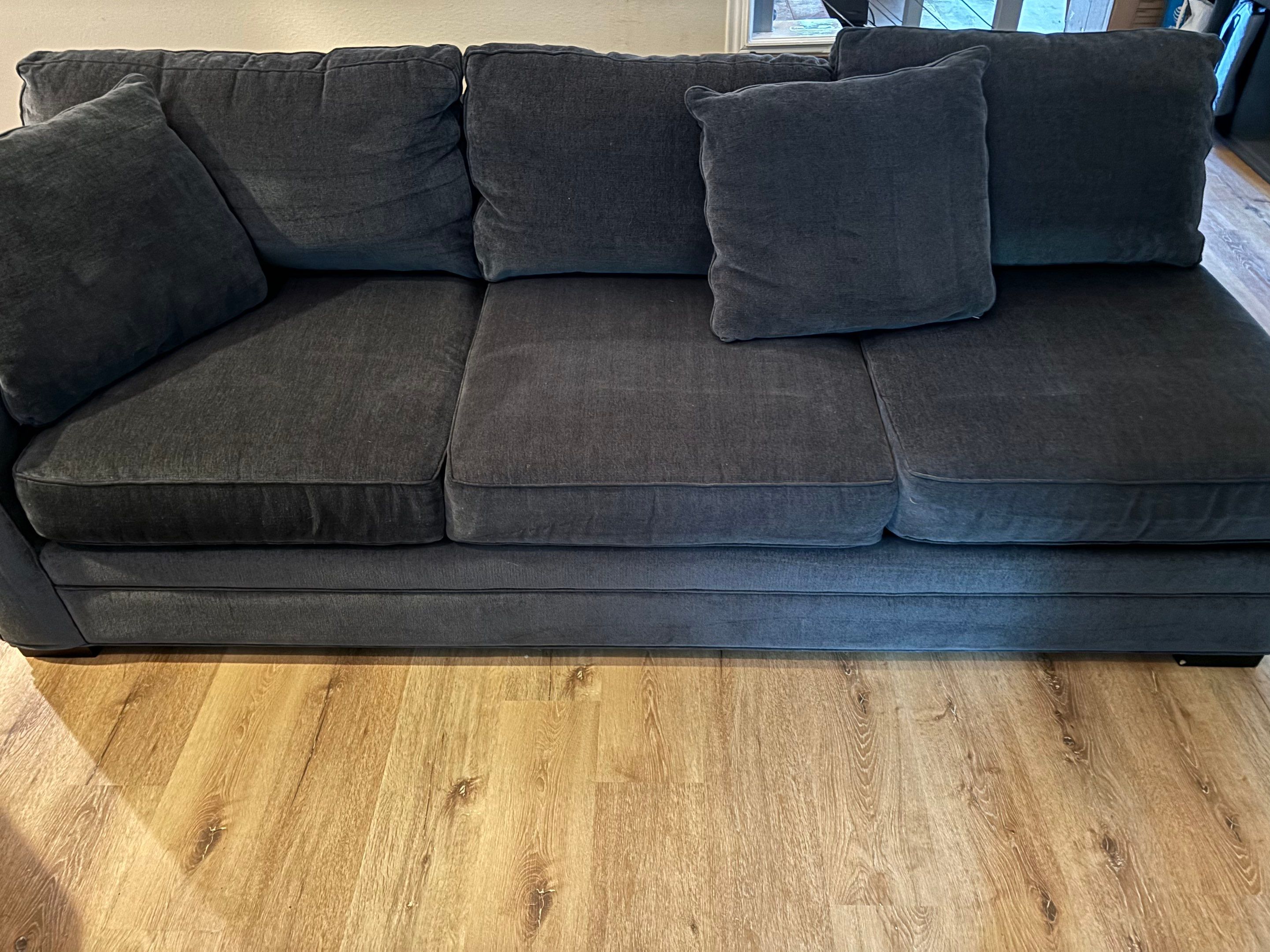 cleaning a fabric sofa and wooden floor surface performing upholstery and floor care services for deep cleaning and maintenance