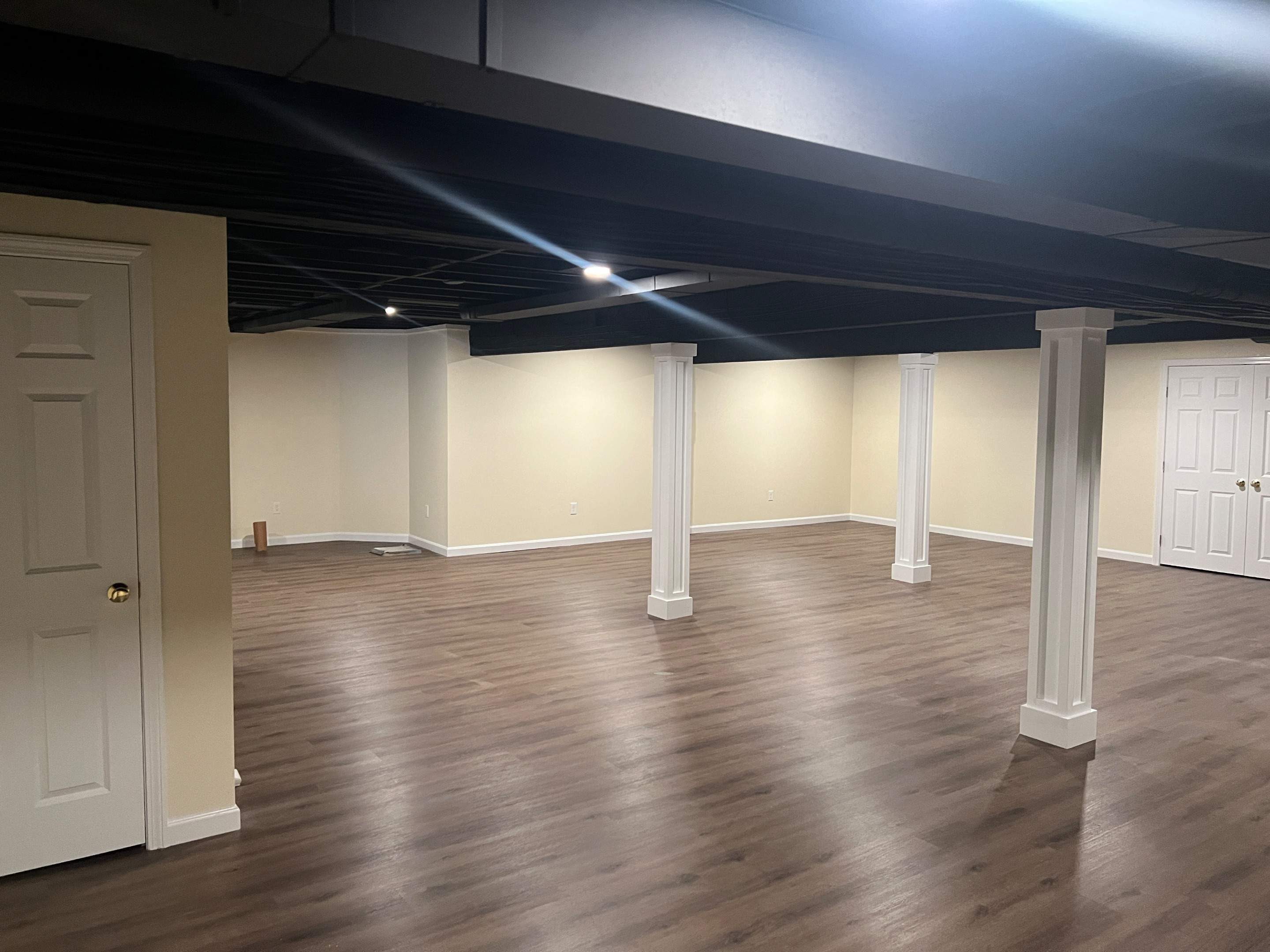 Basement Remodel w/ LVP Flooring & Exposed Ceiling by Chagnon Building & Remodeling LLC