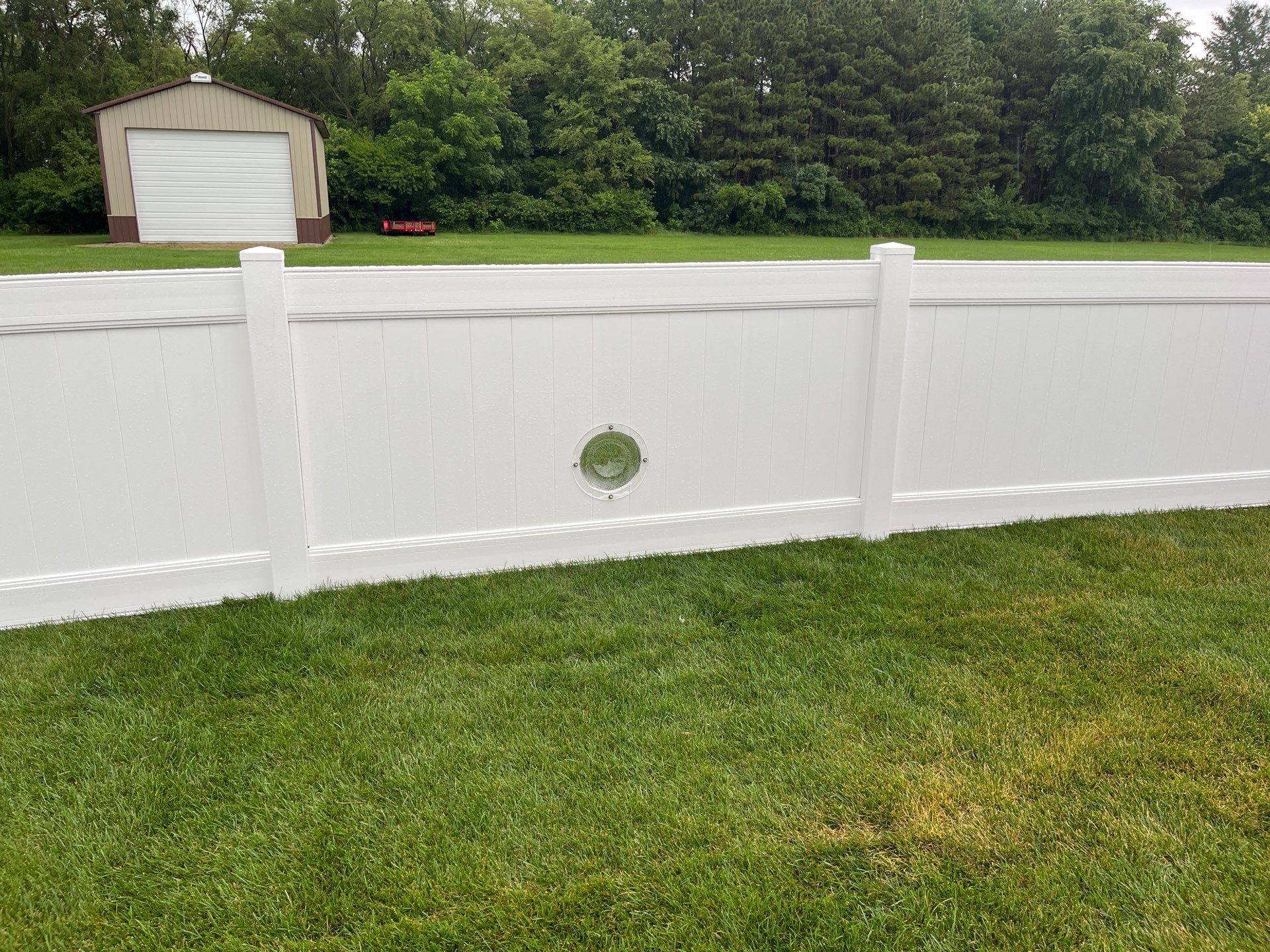 White Vinyl Privacy Fence With Pet Window in Cedar Falls by Perfect Picket Fence and Stain