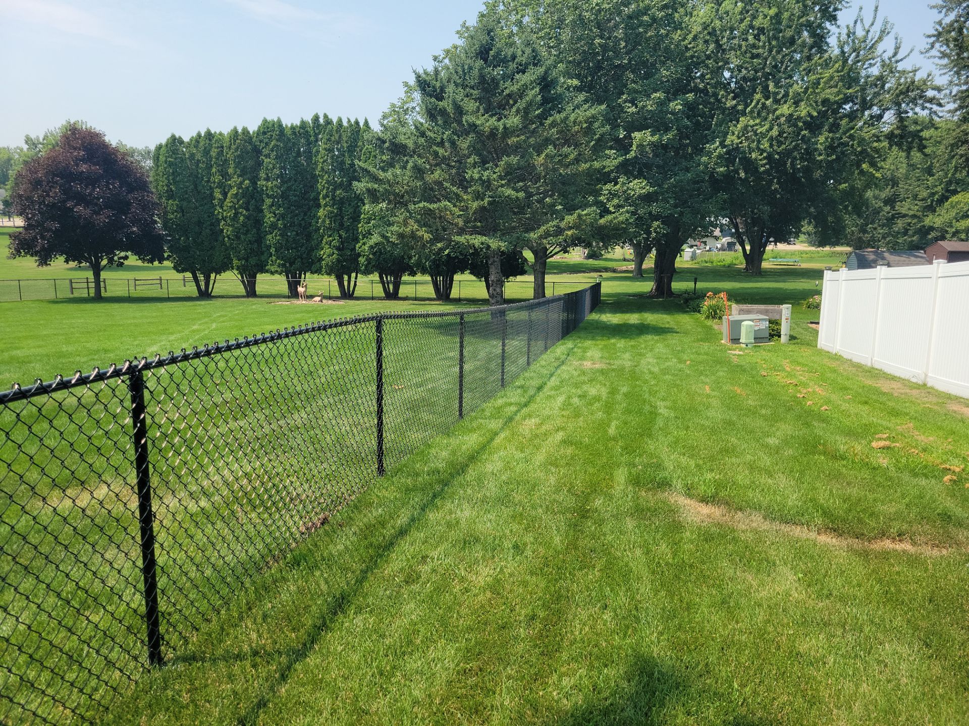 Black Vinyl-Coated Chain Link Fence Installation in New Hampton by Perfect Picket Fence and Stain