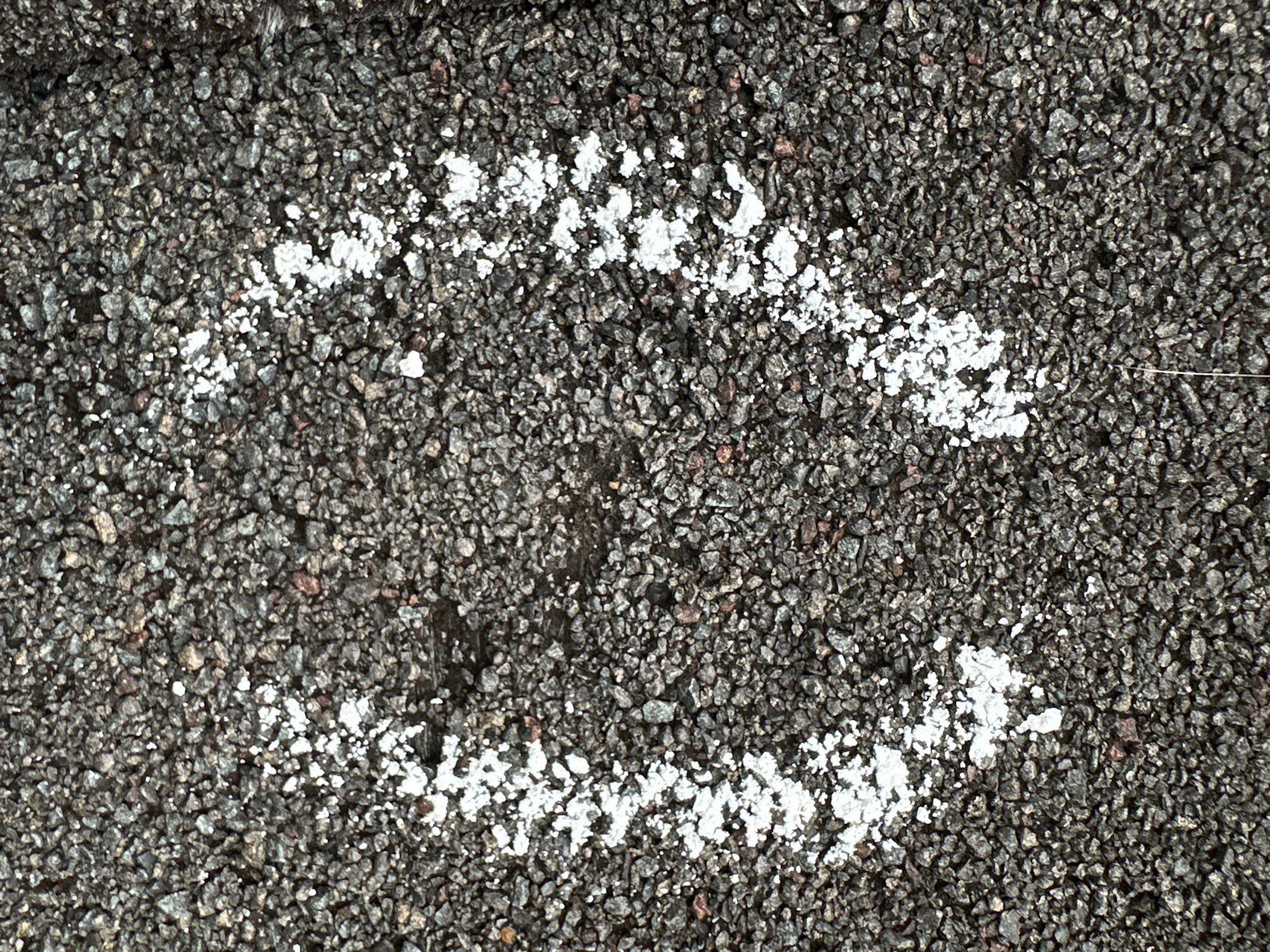 Chalk marked suspected impact area on an asphalt shingle roof in Friendswood