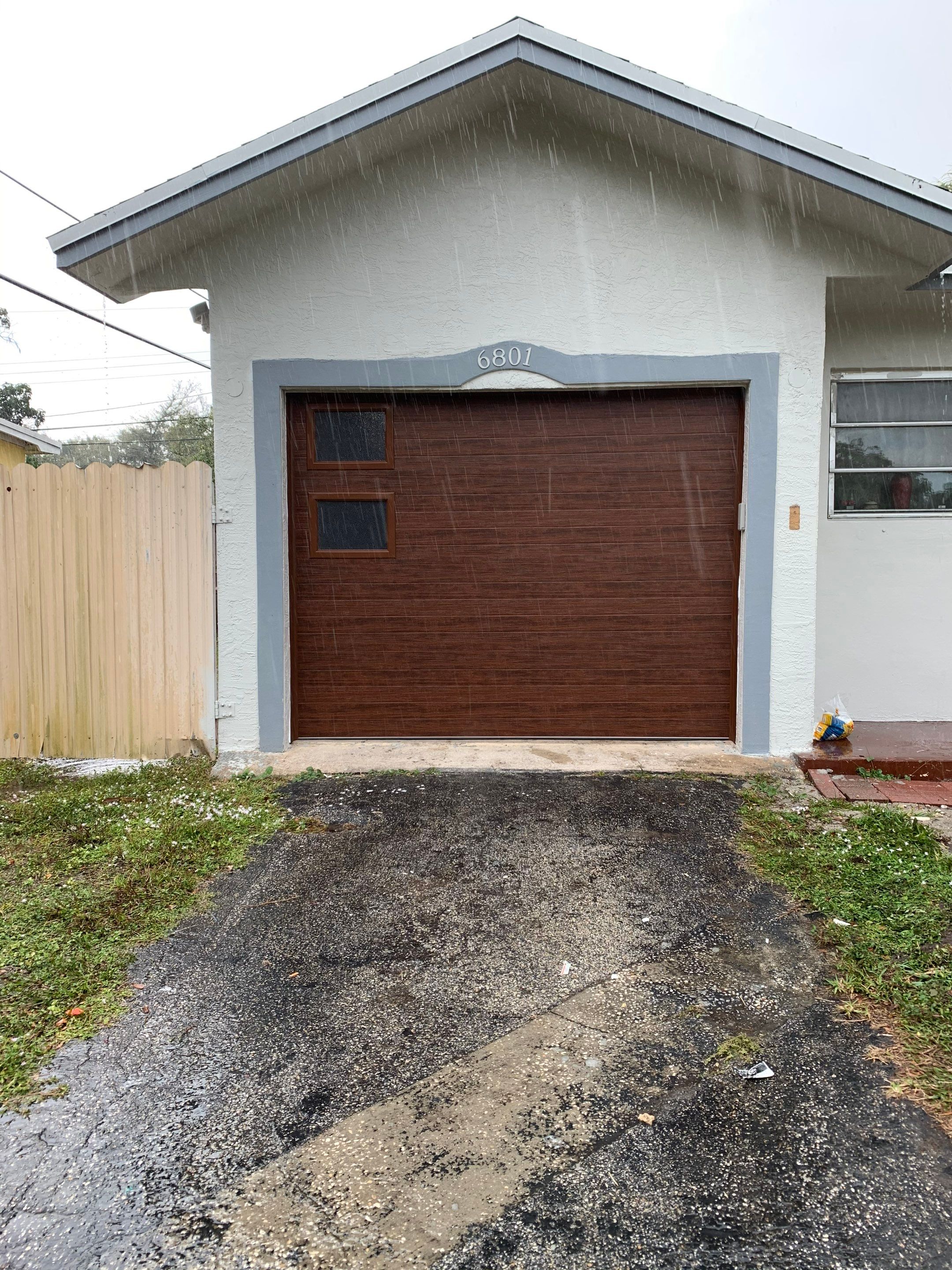 Sectional Garage Door Installation with Wood-Grain Finish in Sunrise - Clopay Modern Steel by The Door Doctor of South Florida, Inc.