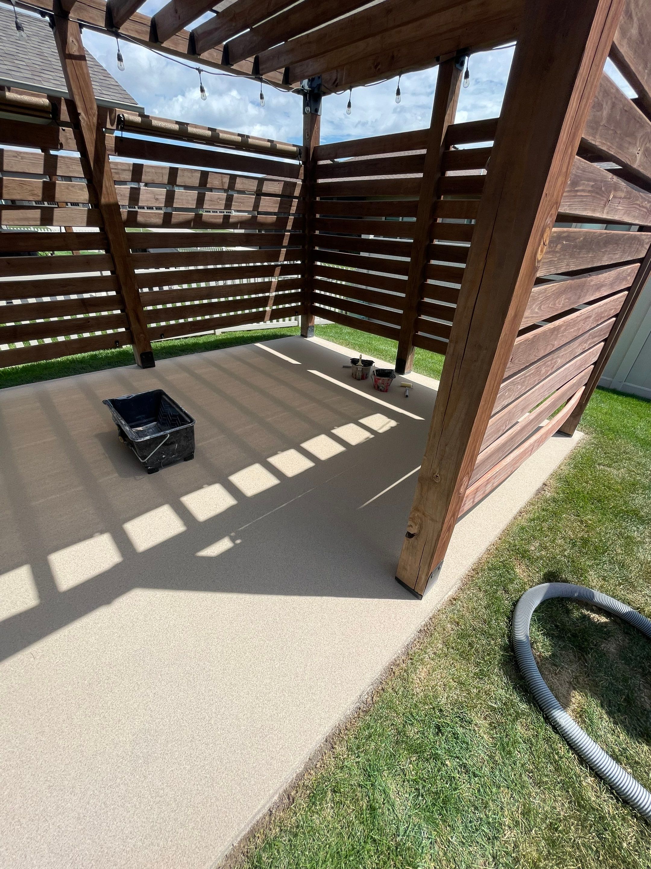 Textured Concrete Patio Coating and Custom Privacy Pergola in Sioux Falls by Select Painting, Coatings & Garage Cabinets