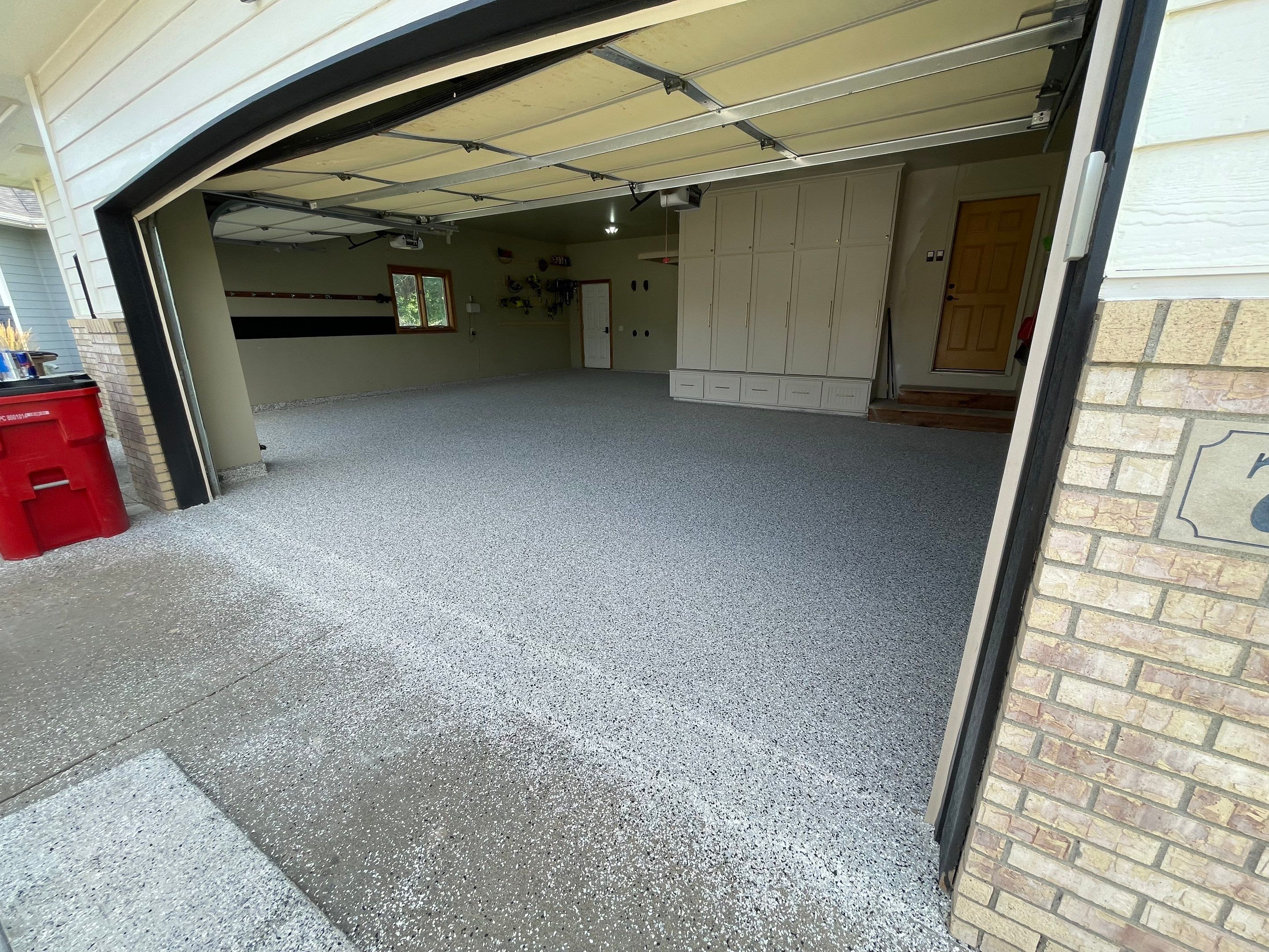 Cabin FEver Flake Garage Floor Coating Installation in Sioux Falls by Select Painting, Coatings & Garage Cabinets