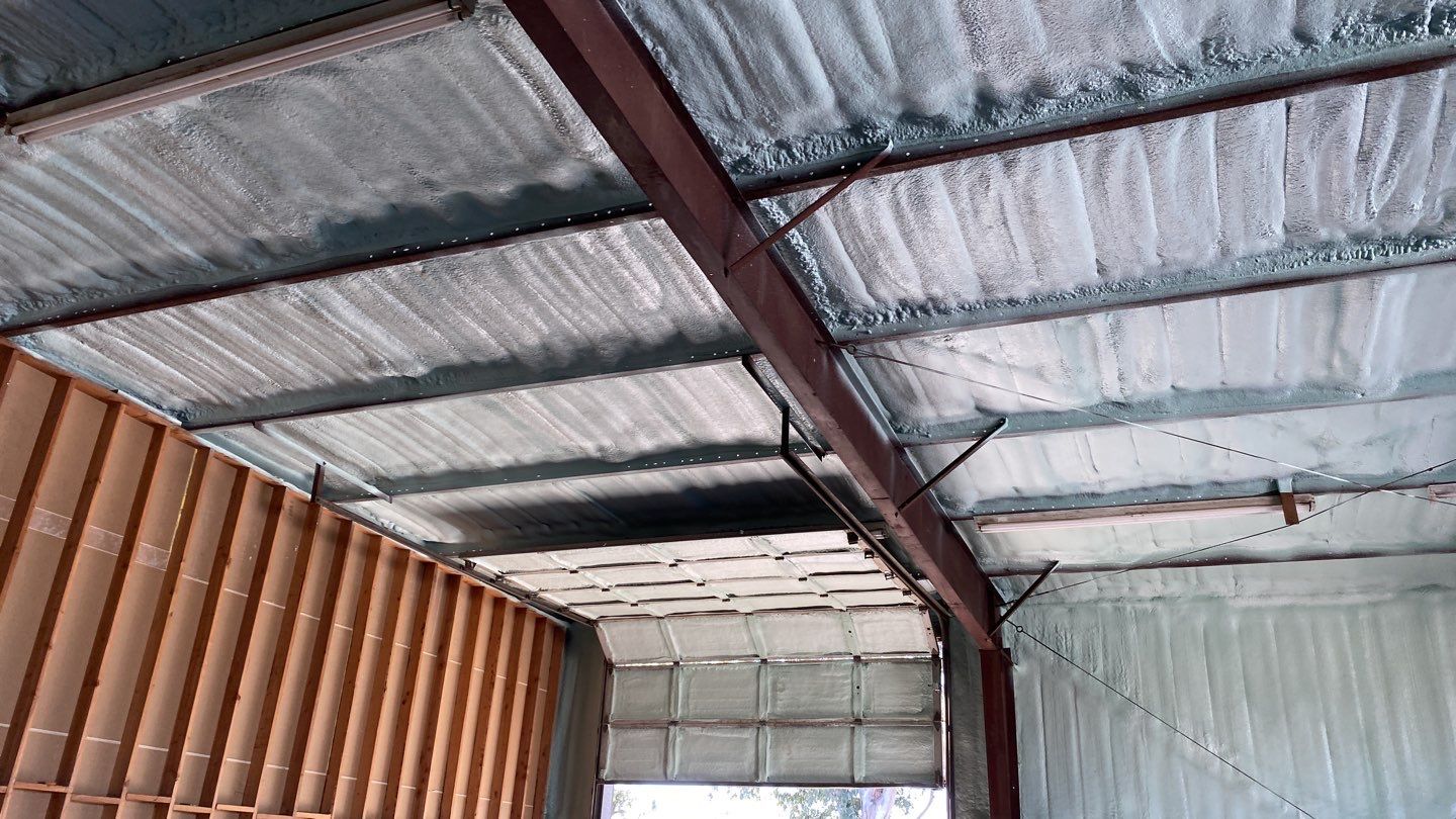 Spray foam insulation on inside of metal industrial building by Straight Edge Roofing Inc
