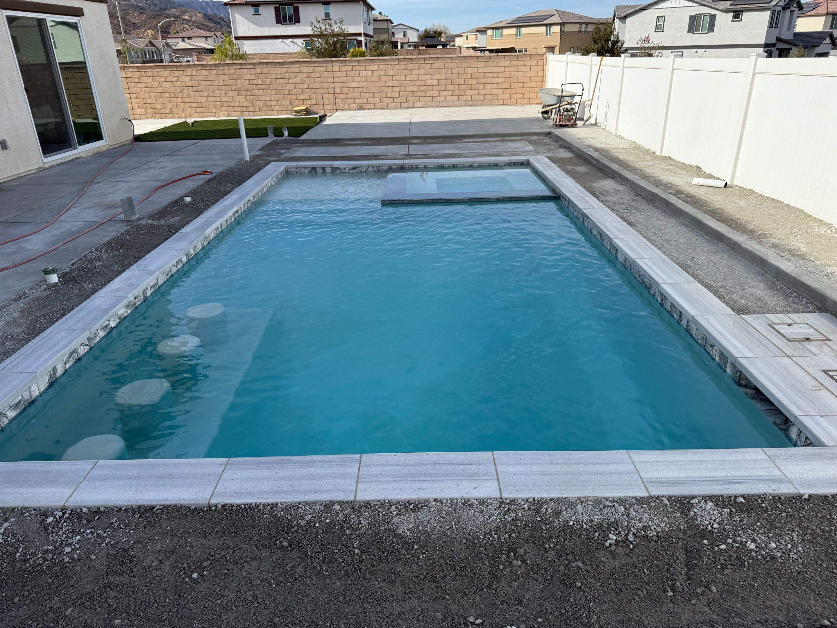 Pool and spa modern shape turf around pool by Premier Pools and Spas Temecula