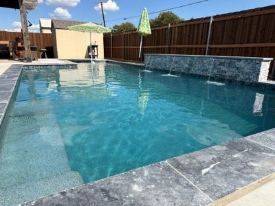 Geometric Pool with Raised Stone Waterfall Wall