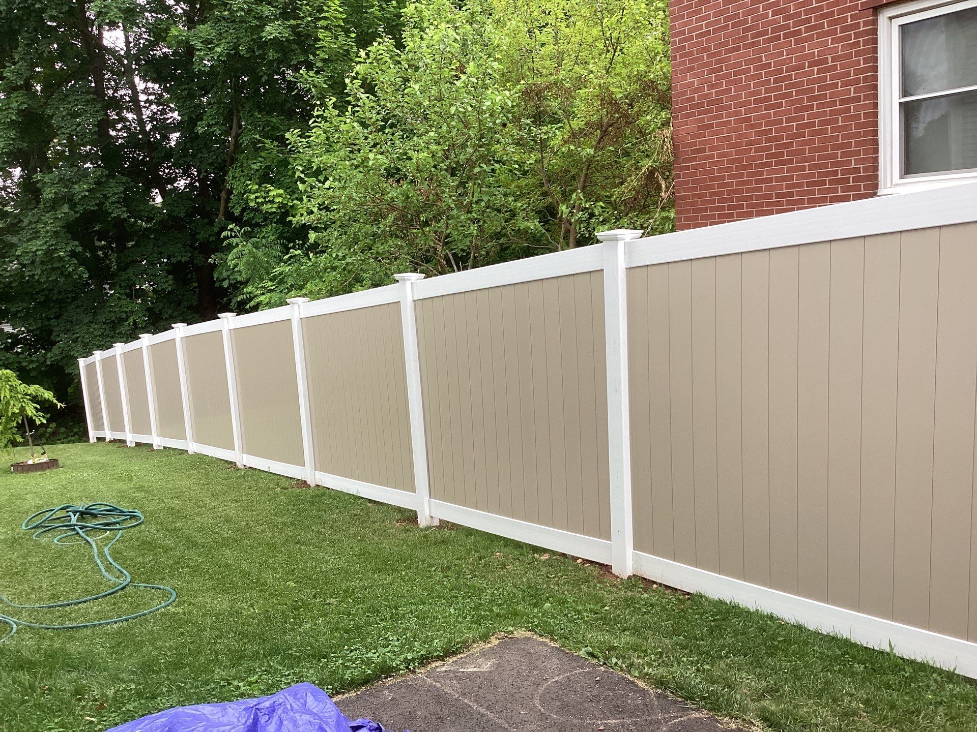 New two tone White and Clay Vinyl privacy fence. by DiGiorgi Roofing and Siding Inc