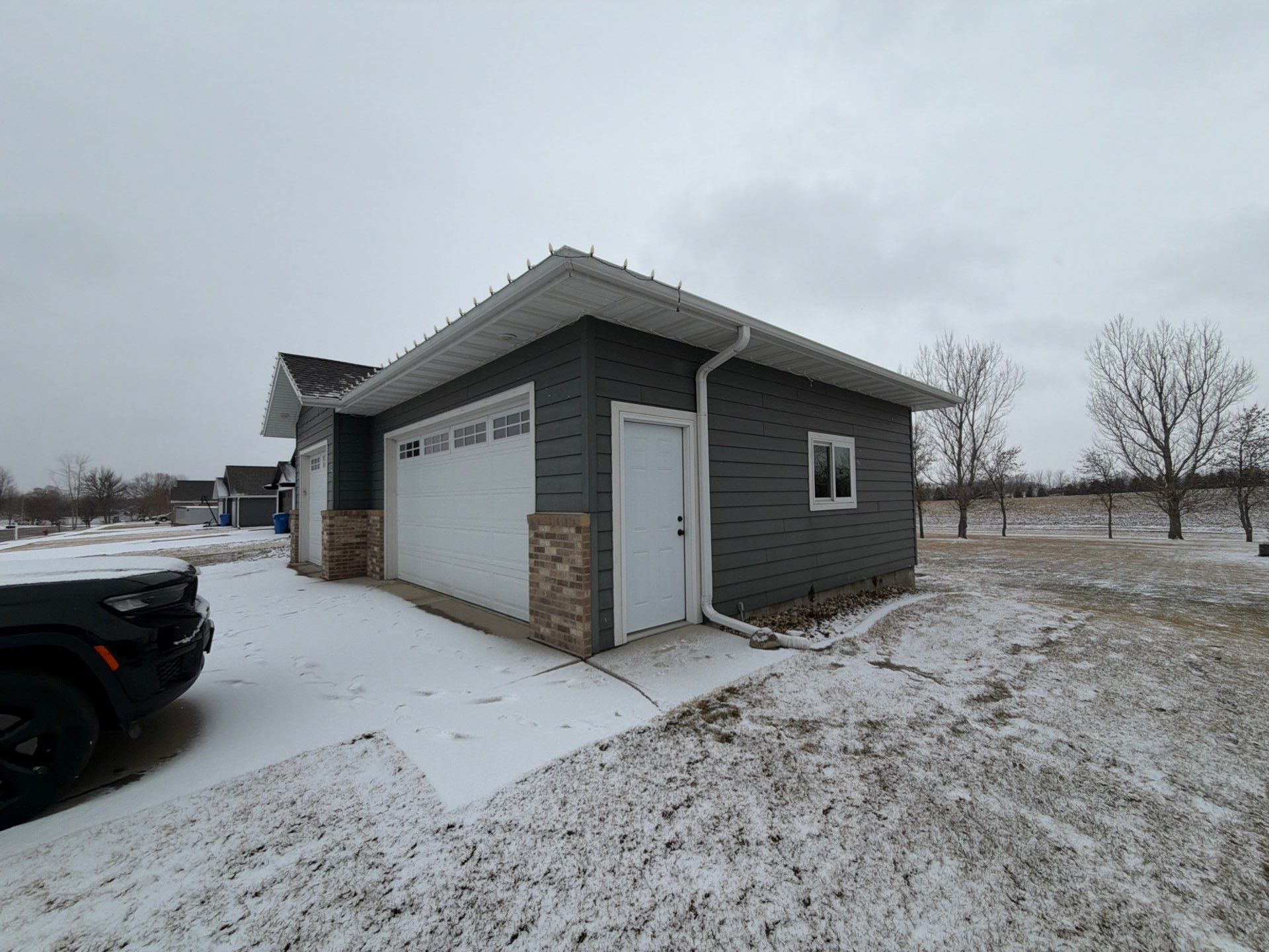 Madison Exterior Remodel with Dark Gray Siding and Stone Accents by Select Painting, Coatings & Garage Cabinets