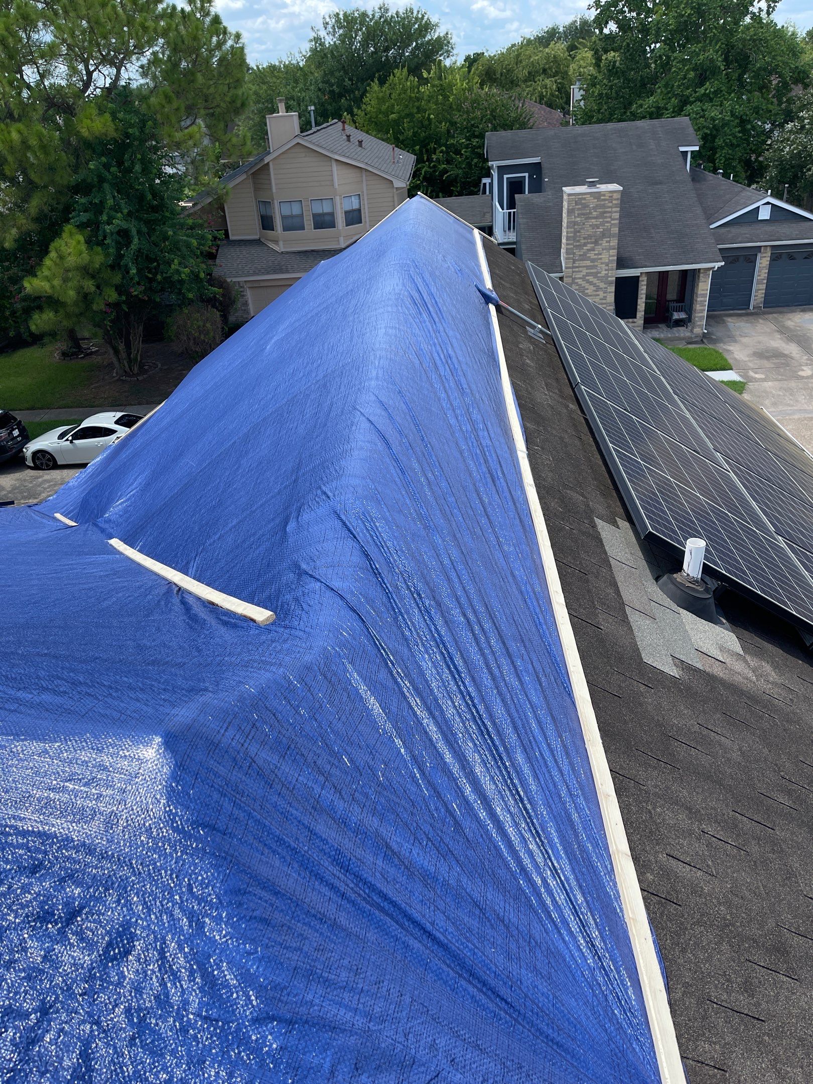 Placement of tarps on the roof. using TARP BLUE by V General Contractors 