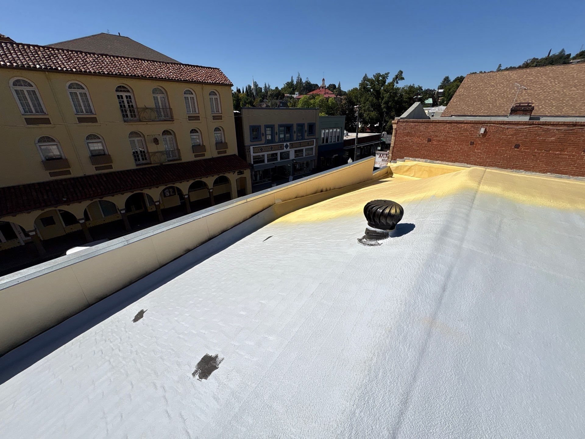 Foam and coatings on commercial roof by Straight Edge Roofing Inc