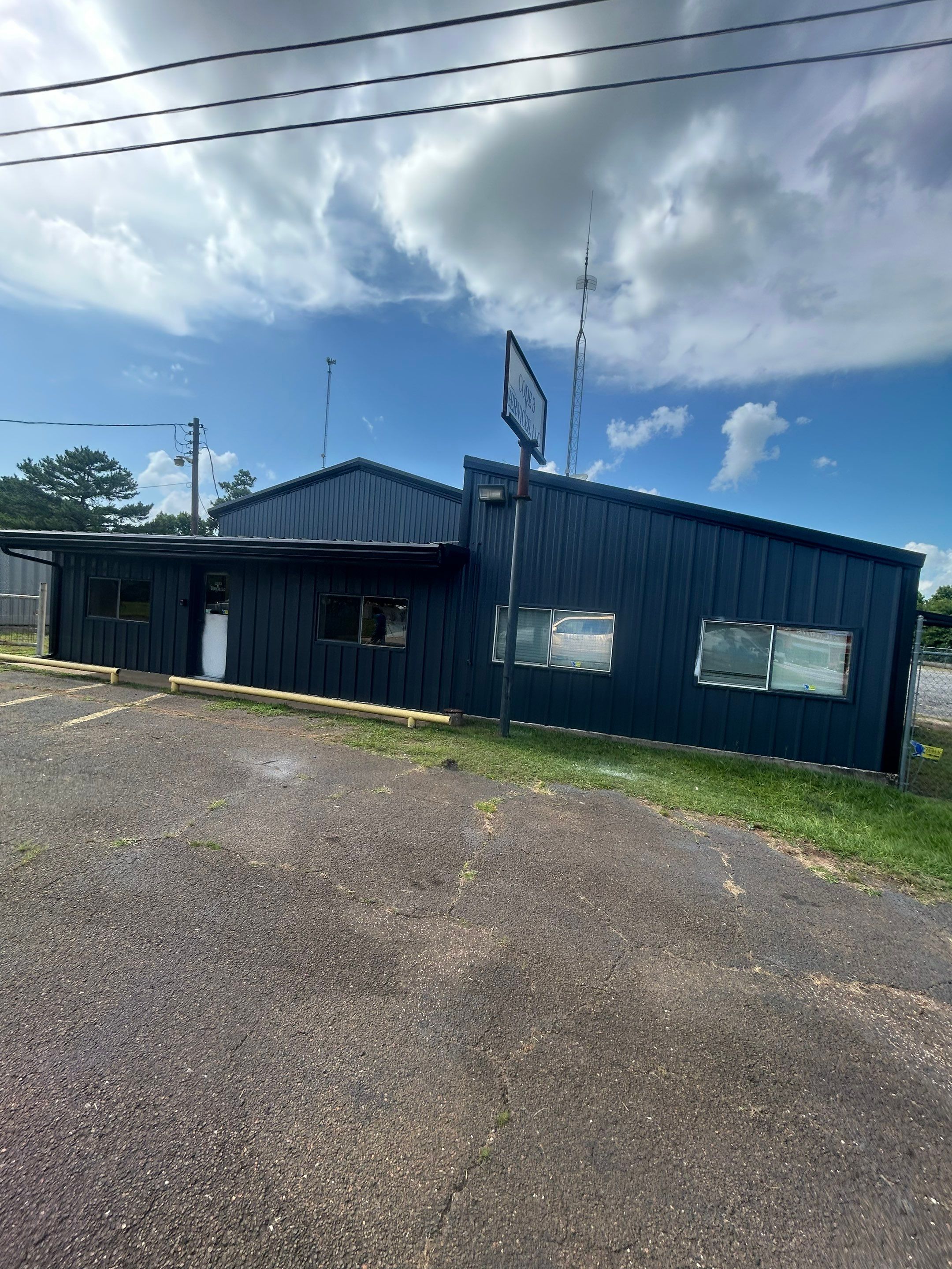 Exterior Painting in Kilgore, TX | Metal Building Transformation from White to Grey by Quality Coats Painting