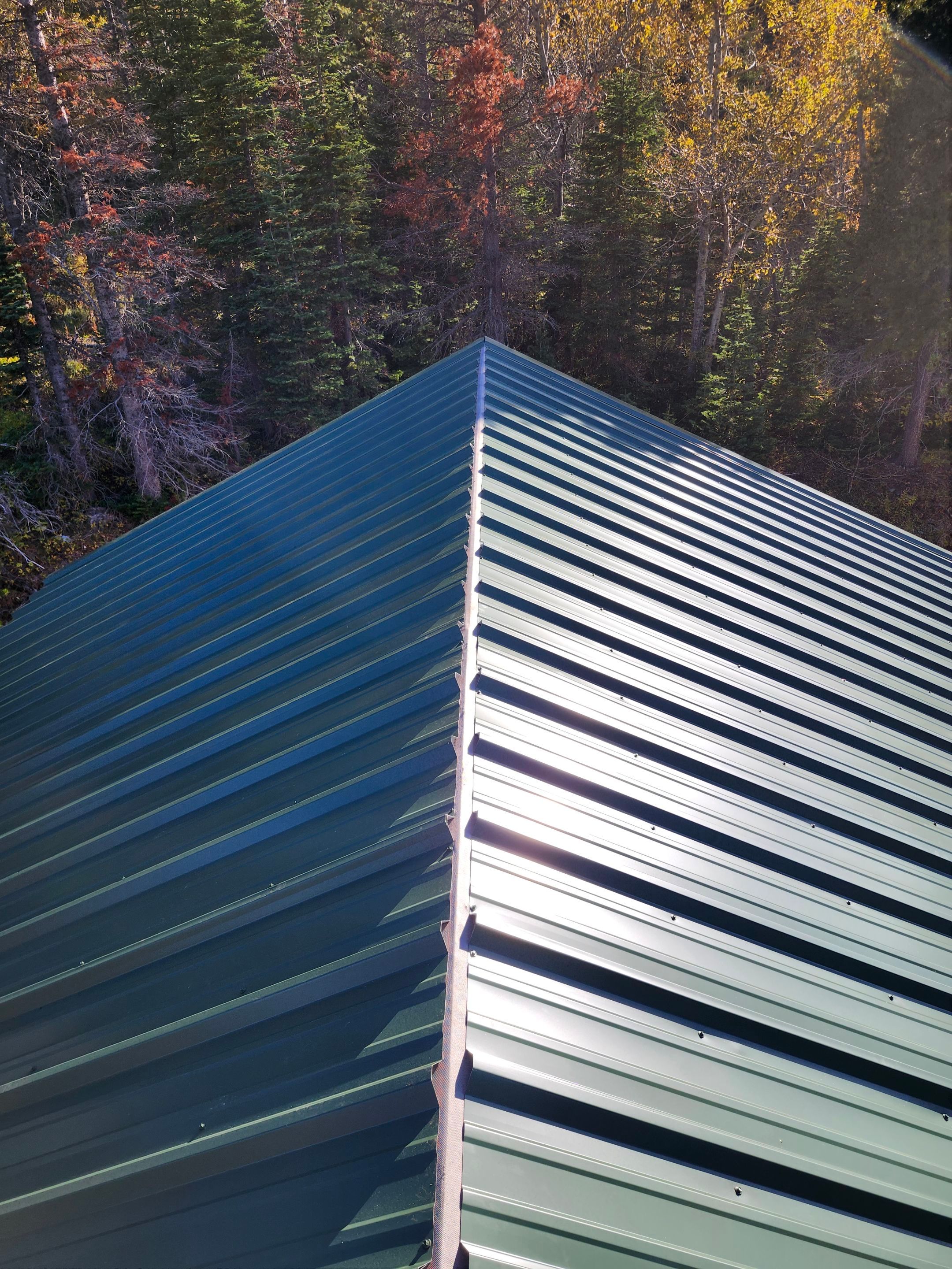 Green Standing Seam Metal Roof Installation in East Glacier Park by KQC Roofing