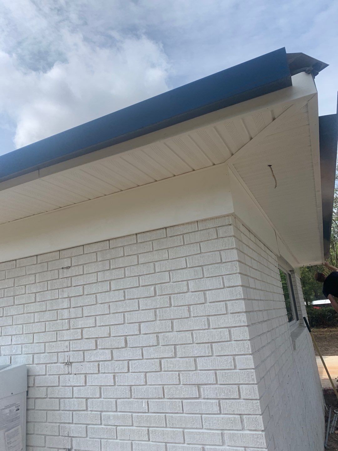 White Seamless Gutters and Black Downspouts by Gutter Professors
