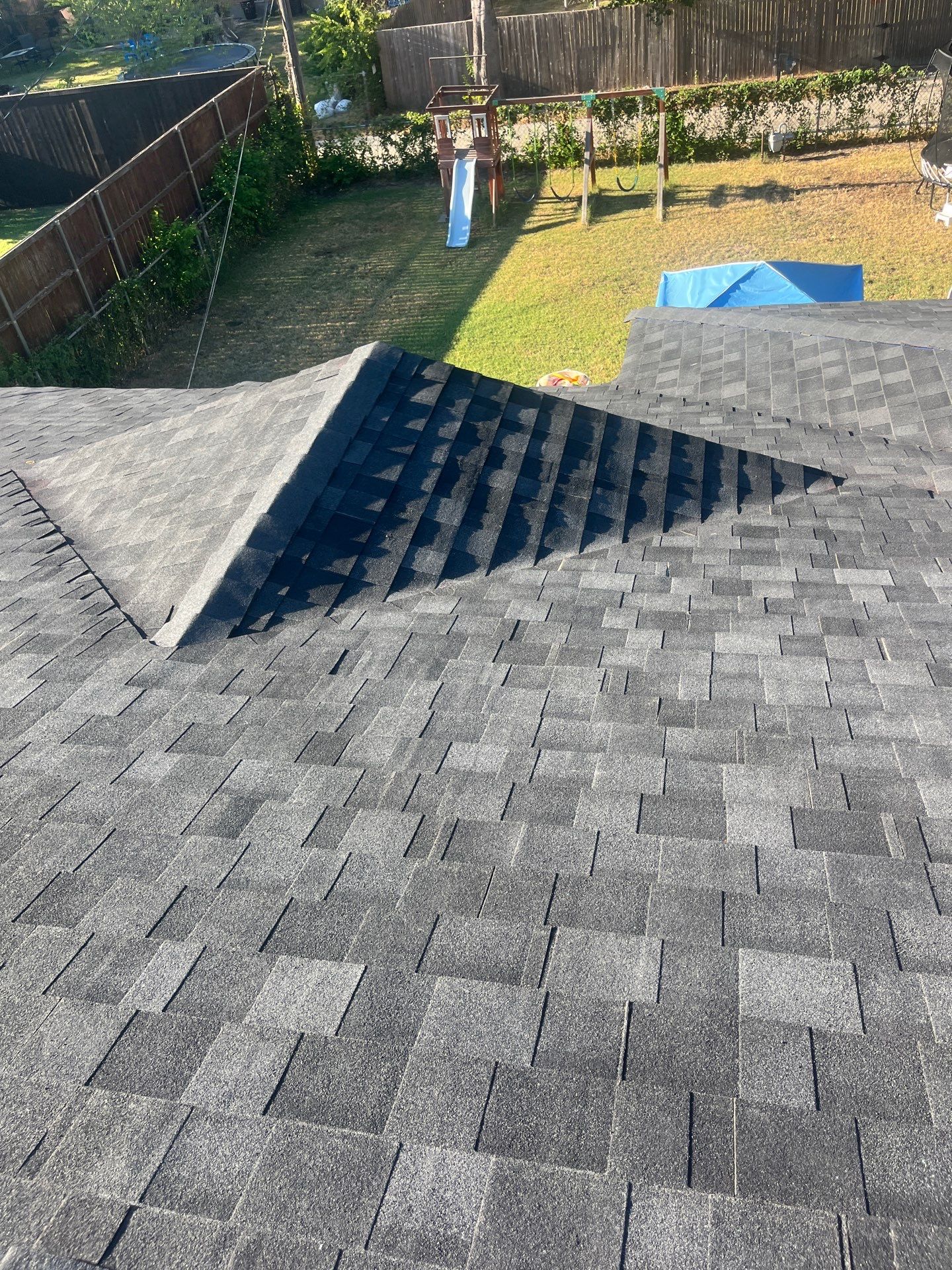 White brick/light gray shutters with IKO Granite Black  by Tejas Roofworks + Restoration