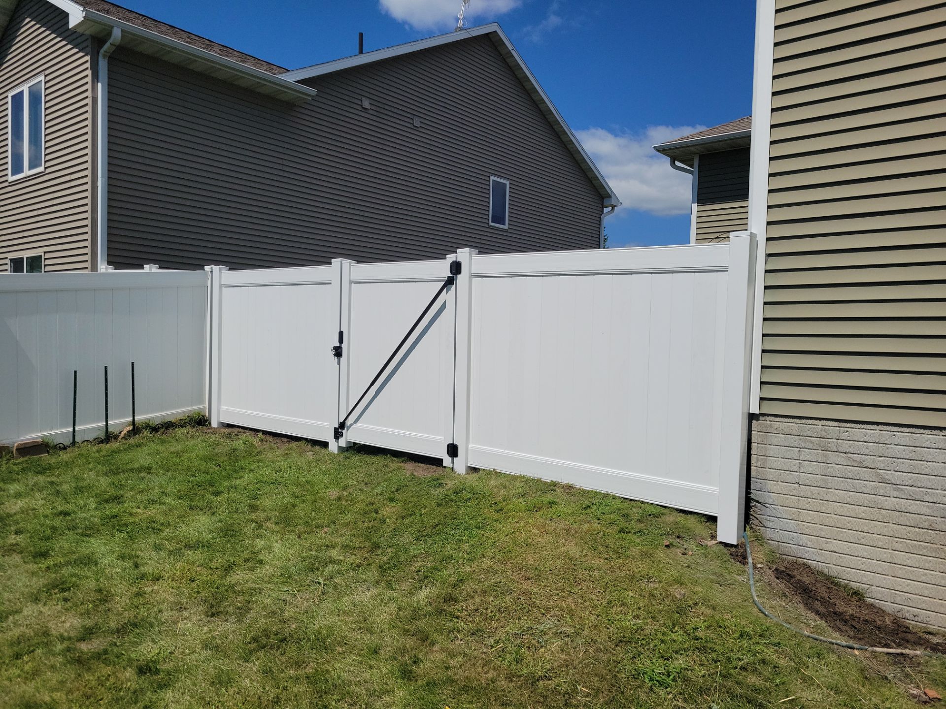 White Vinyl Privacy Fence and Ornamental Gate Installation in Janesville by Perfect Picket Fence and Stain