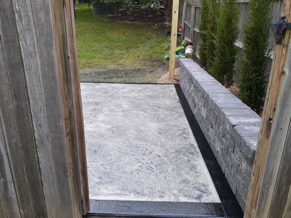 Back Yard Stamped Concrete Patio by LAND ESCAPES LLC