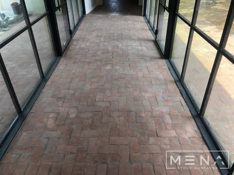 Kitchen, outdoor kitchen and pool brick floor installation by Mena stone surfaces