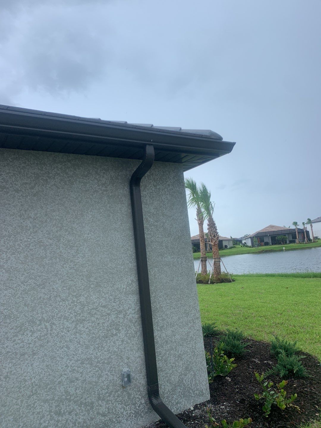 Seamless brown gutter and downspouts installation in Estero, FL  by Gutter Professors