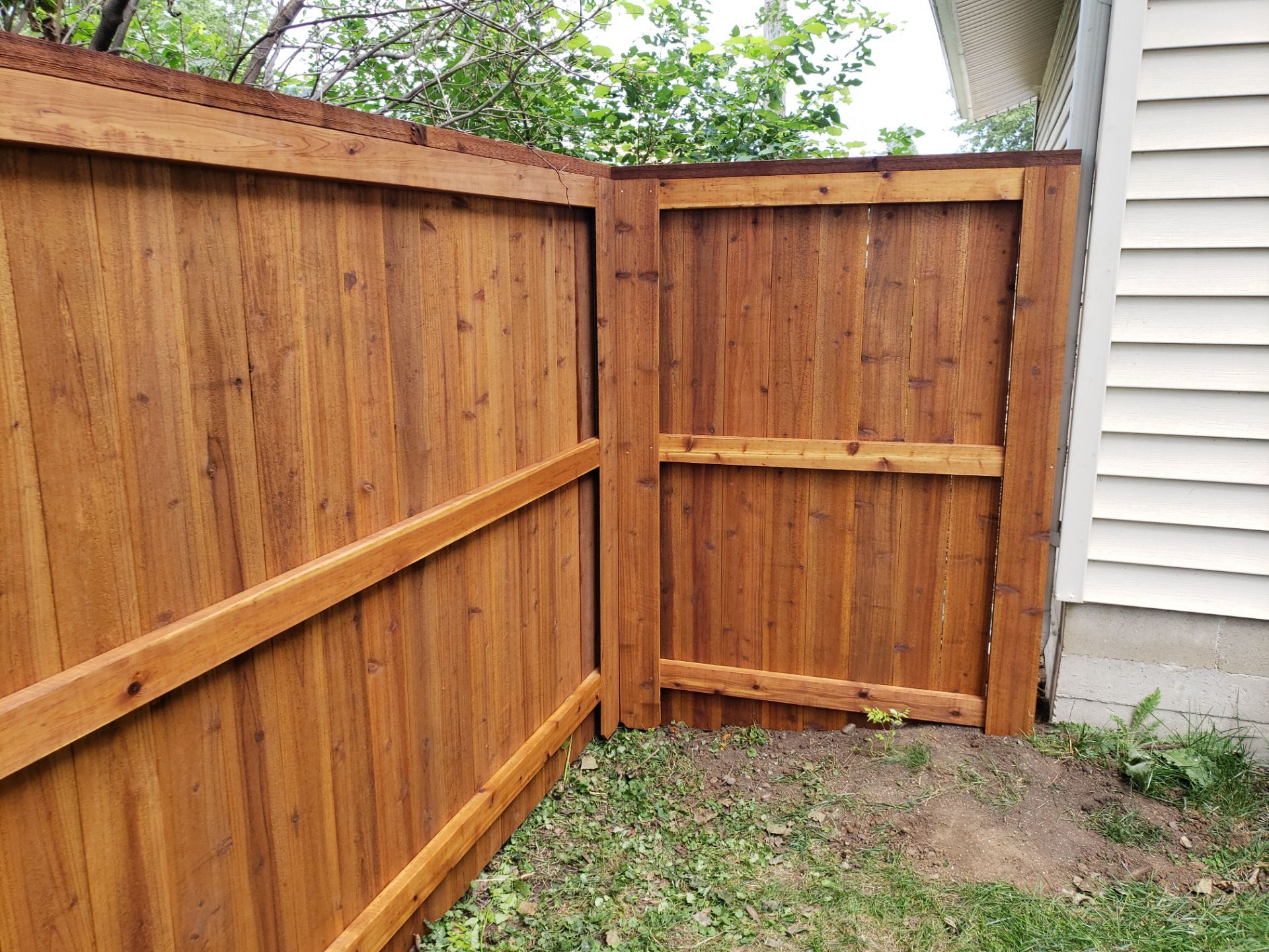 Custom Cedar Privacy Fence with Decorative Gate Windows in Cedar Falls by Perfect Picket Fence and Stain