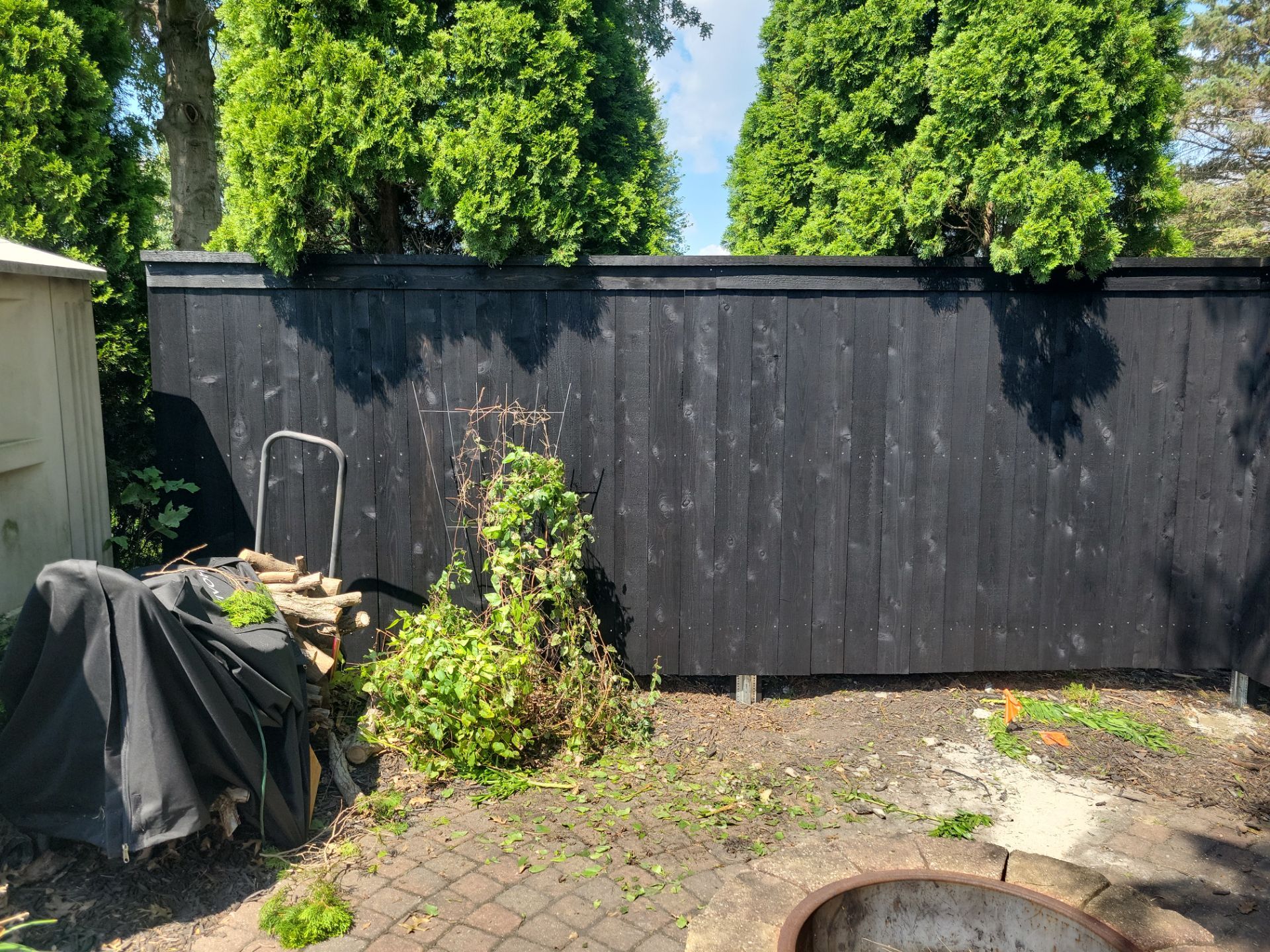 Black Wood Privacy Fence and Circular Stone Patio in Waverly by Perfect Picket Fence and Stain