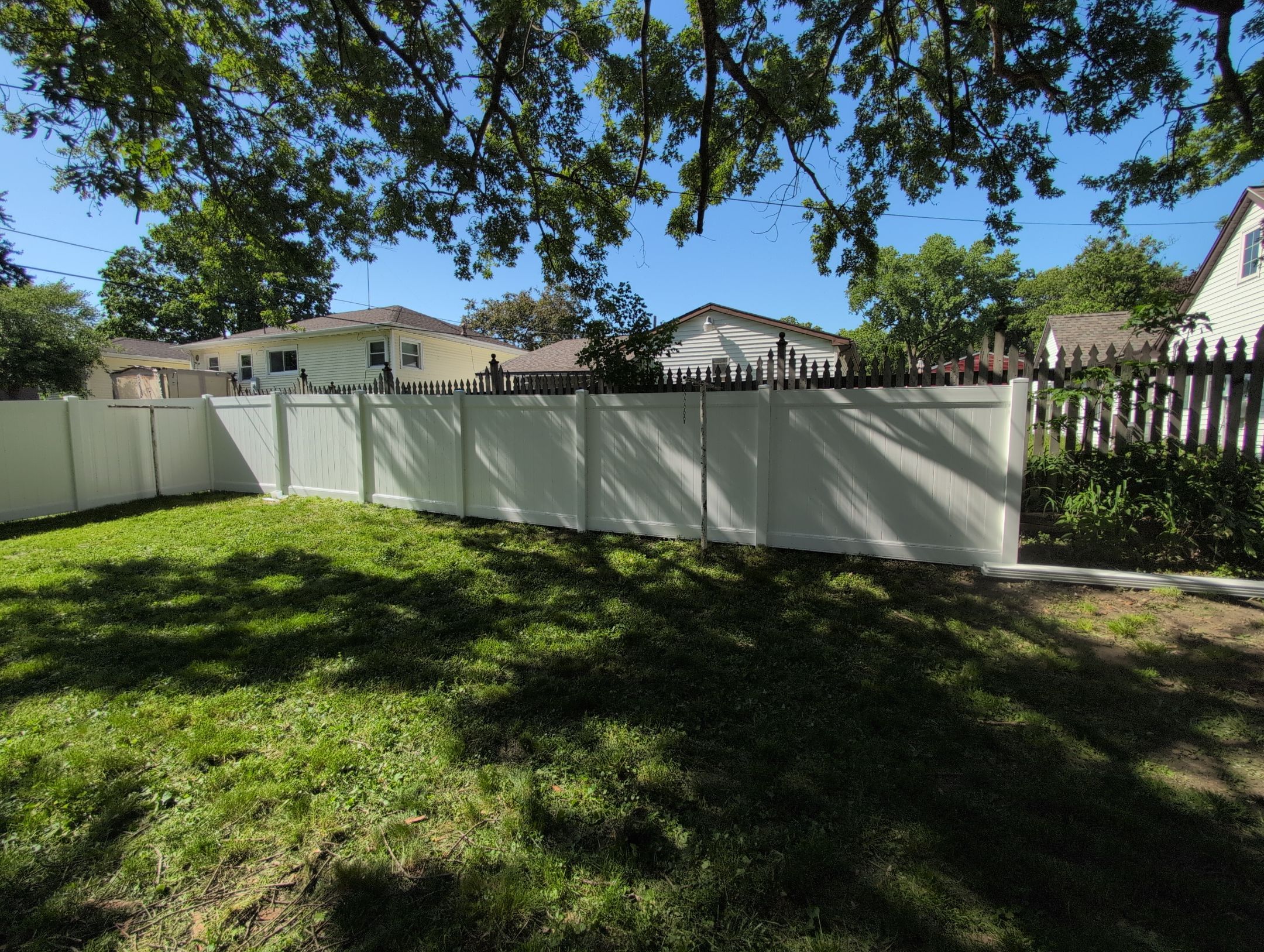 White Vinyl Privacy Fence and Double Gate Installation in Cedar Falls by Perfect Picket Fence and Stain